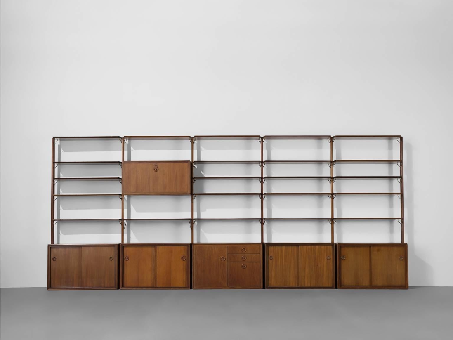 Wall unit, teak, brass, The Netherlands, 1950s.

This large very large wall unit is well-designed. Although the size of this cabinet is what draws the intention, the devil is in the detail. The handles are executed with a protruding ring and a brass
