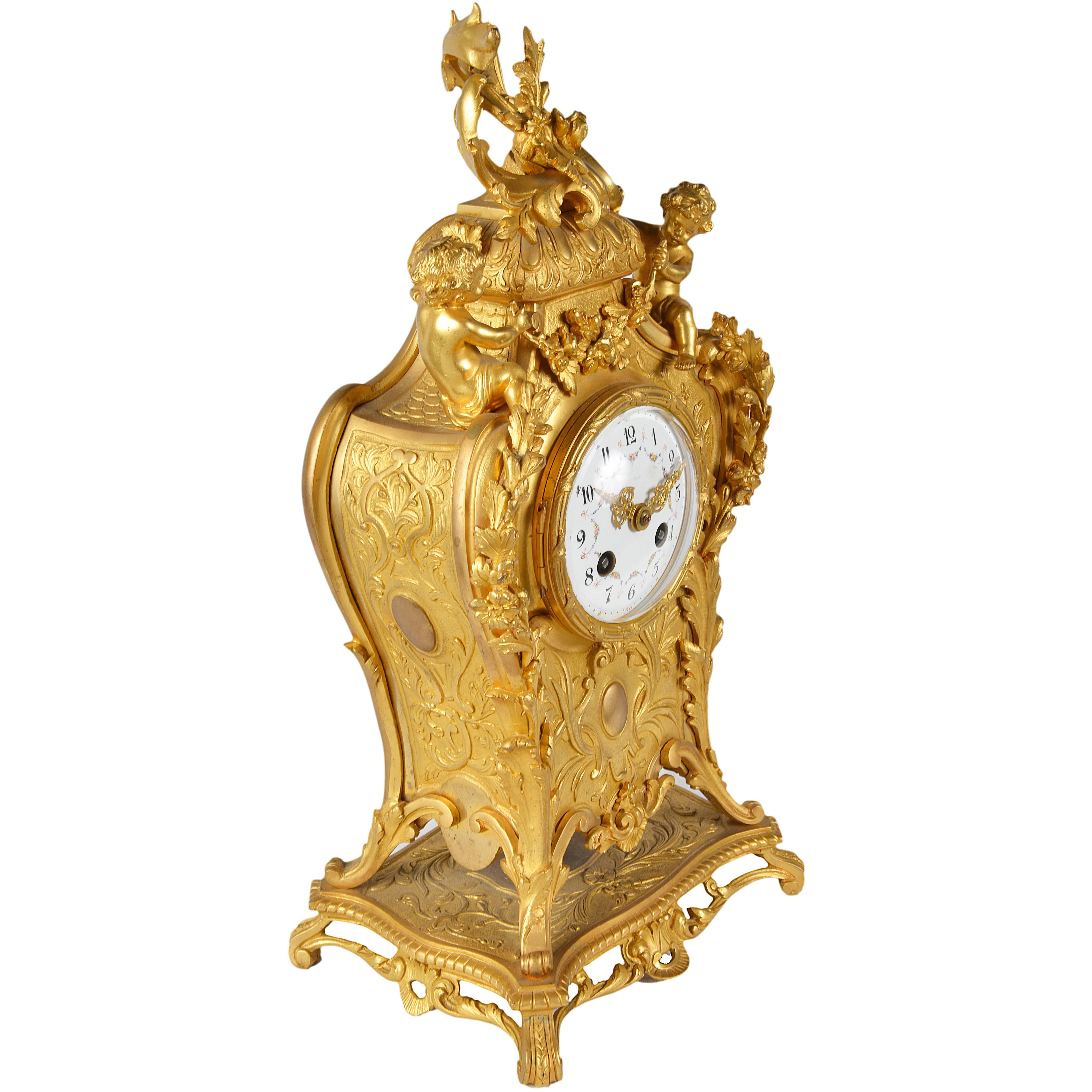 A good quality 19th century Louis XVI style gilded ormolu mantel clock, having scrolling C scroll and foliate decoration with putti on either side of the enamel dialled clock face, chiming on the hour and half hour and eight day duration.