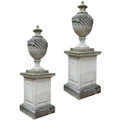 Pair of 20th Century Composition Stone Lidded Urns on Plinths