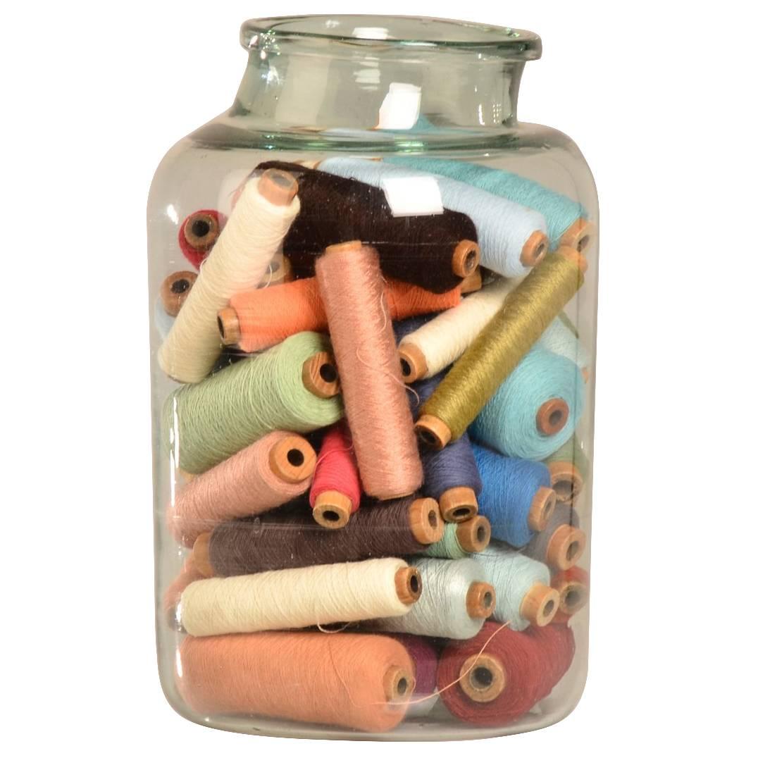Hand Blown Antique Glass Bottle filled with Bobbins circa 1920