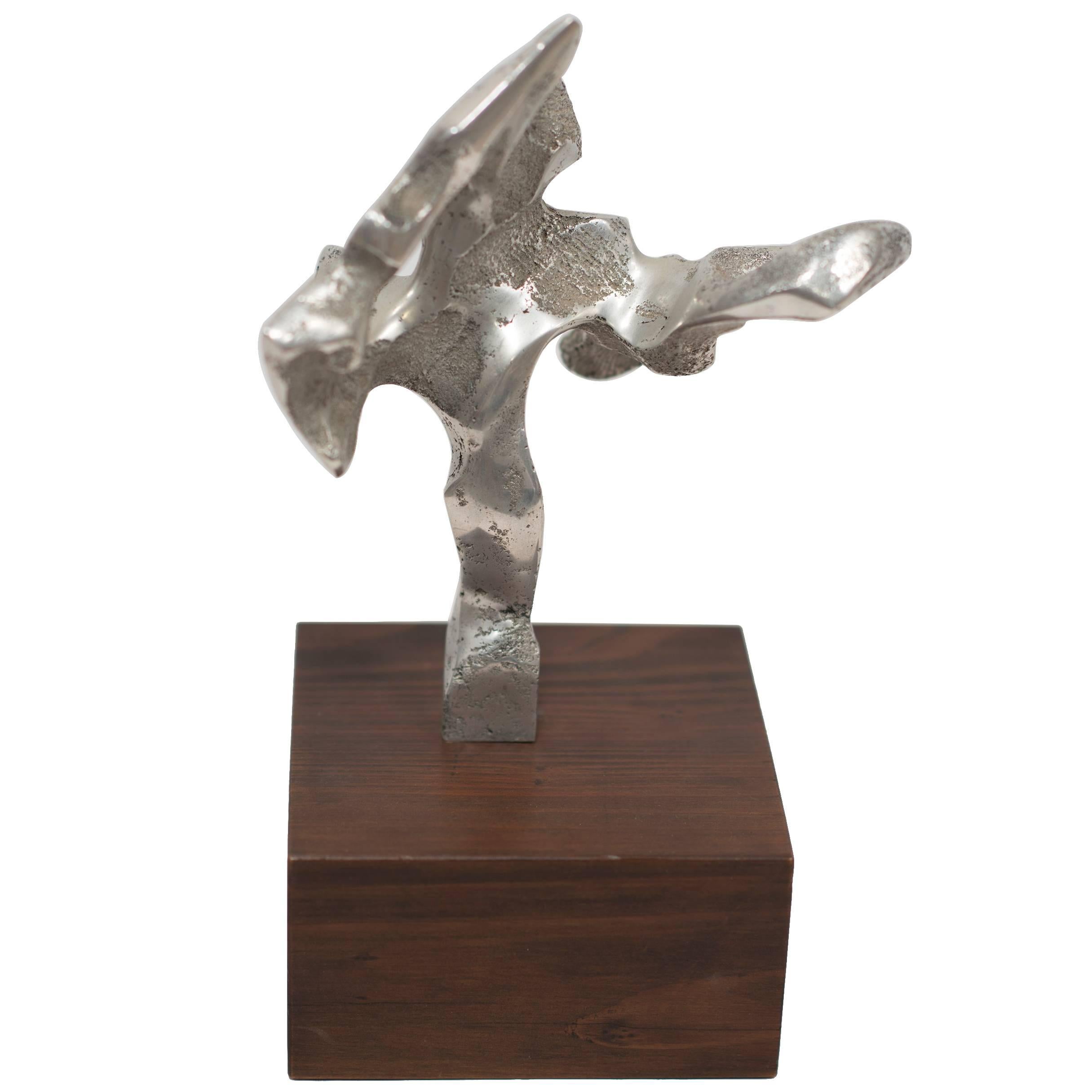 A detailed abstract metal sculpture with a wooden base. A small table-top gem of intricate details and refined free forms. The designer and/or artist is unknown but the source of this piece is from an extremely reputable dealer and purchased at a