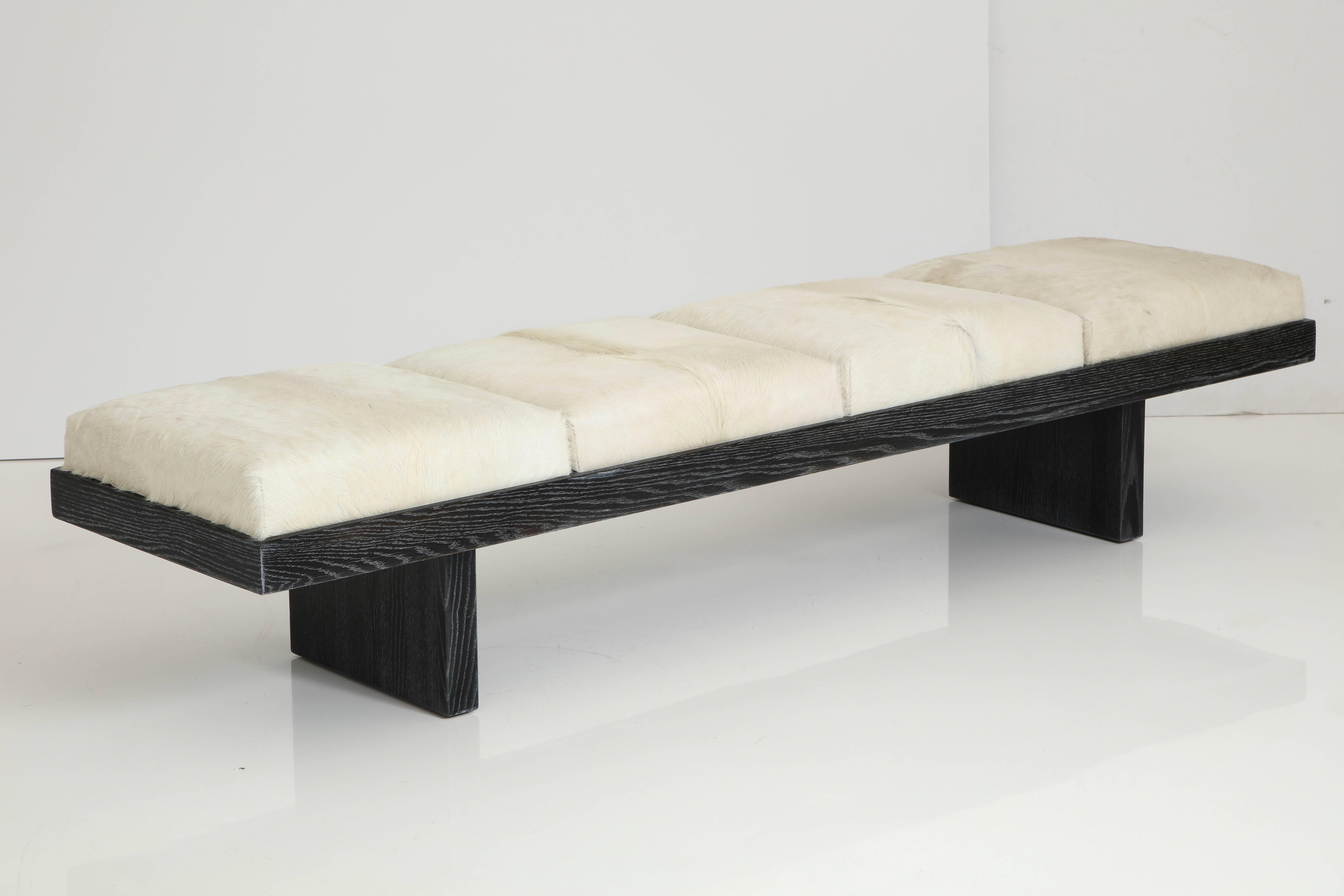 Modern plinth base solid Oak bench with a custom cerused black or white finish with four white calf skin hide seats. Labeled.