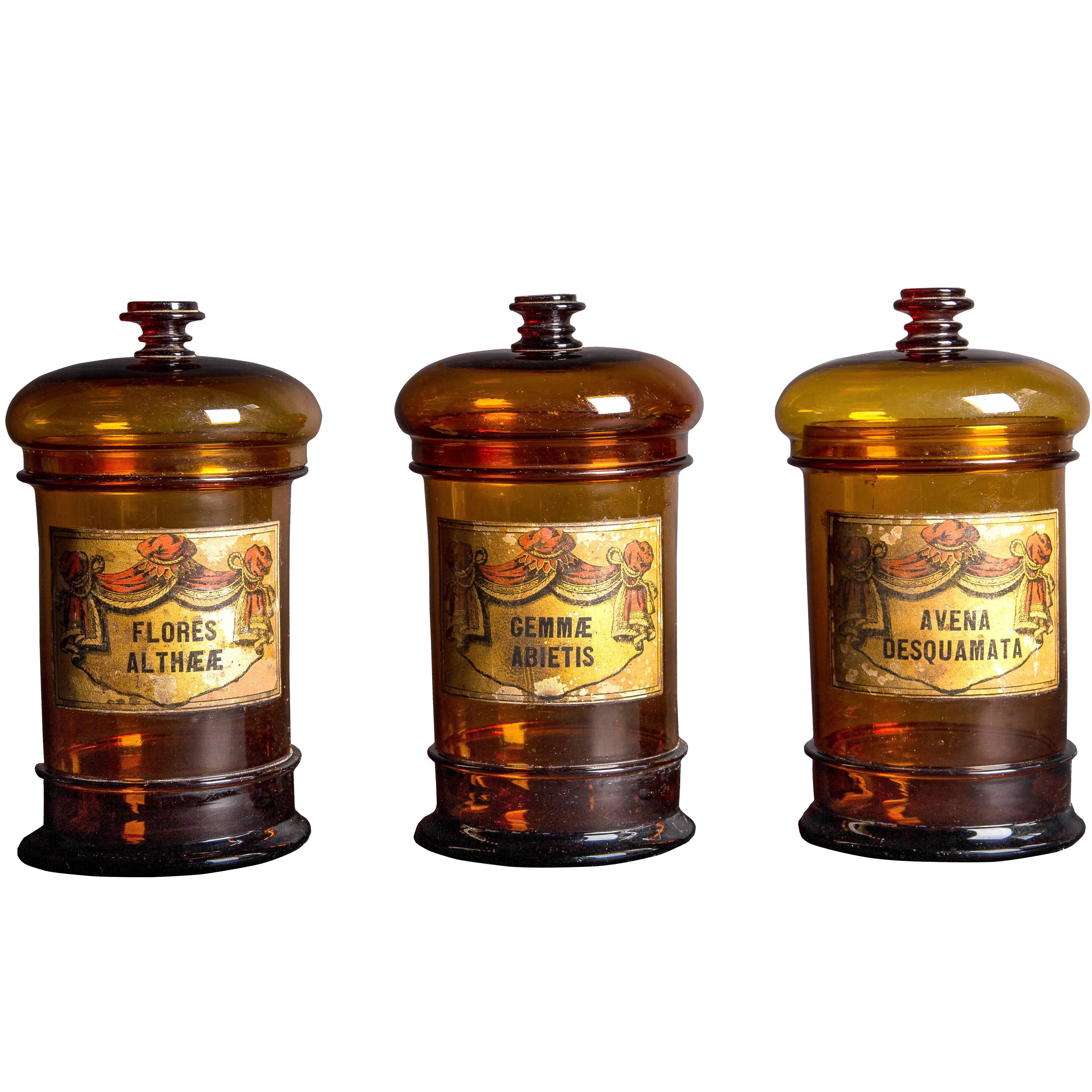 Three Balloon Lid Glass Apothecary Jars with Original Illustrative Labels