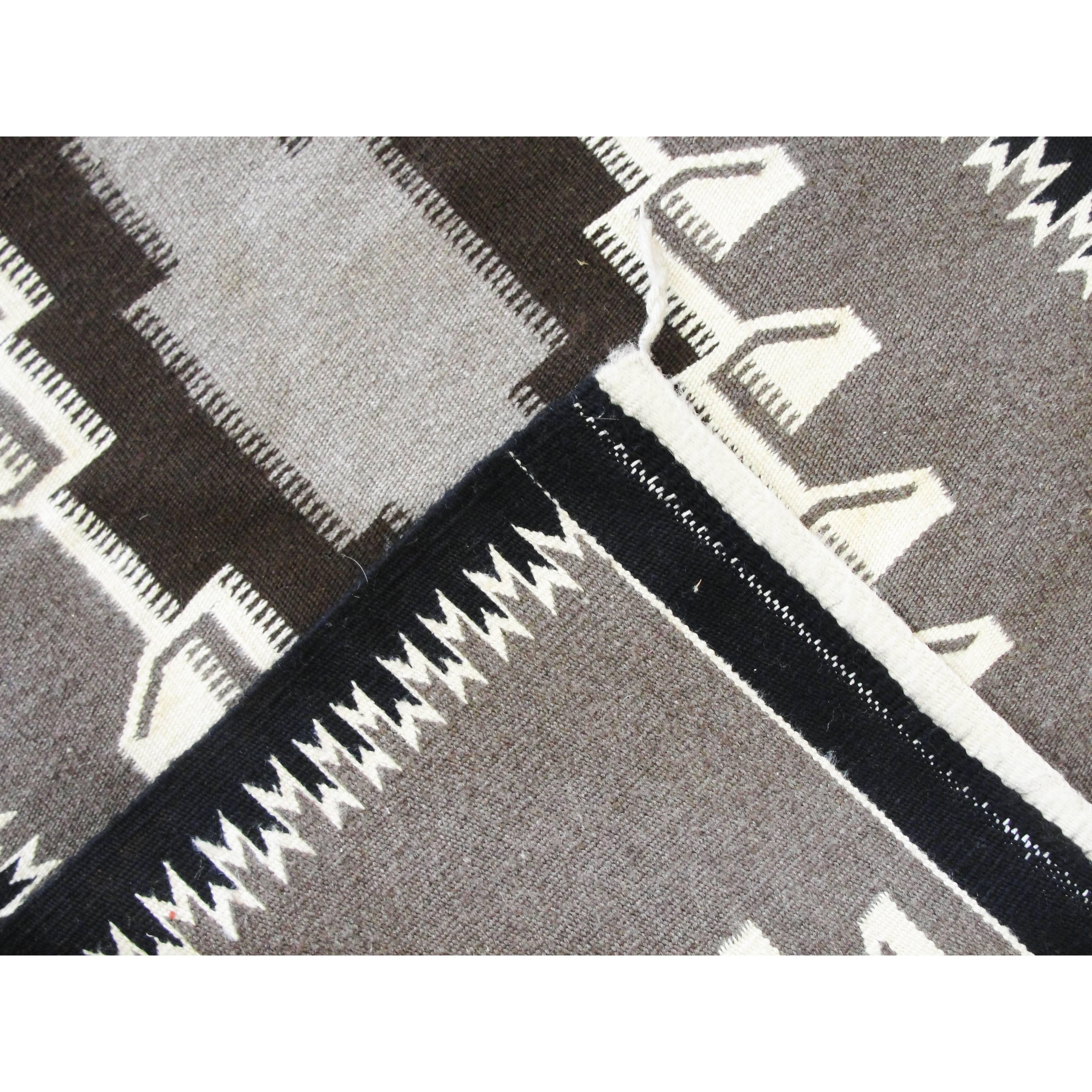 This is a really majestic, old style Two Grey Hills weaving circa 1940s or 1950s. The rug is made completely of hand-shorn wool and is hand carded and spun as well. The colors are completely natural. This is a heavy well-made weaving that has seen