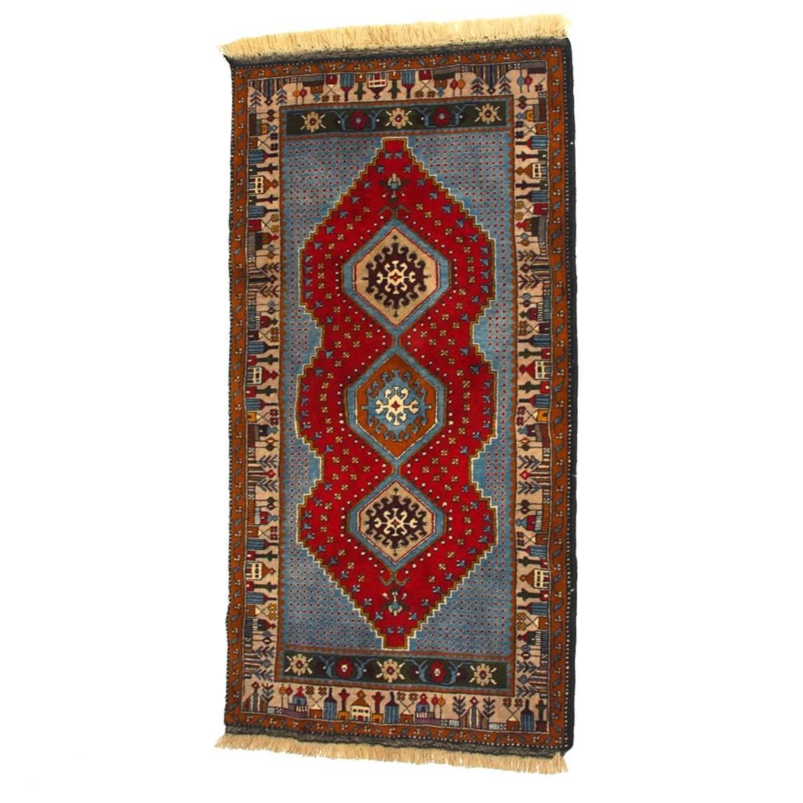 Fine vintage Turkish Yahyali rug or carpet featuring brilliant shades of blue over red. Centered by a triple hexagon pattern and an interesting border of village structures and trees. Yahyali carpets are known for their fine quality and attractive