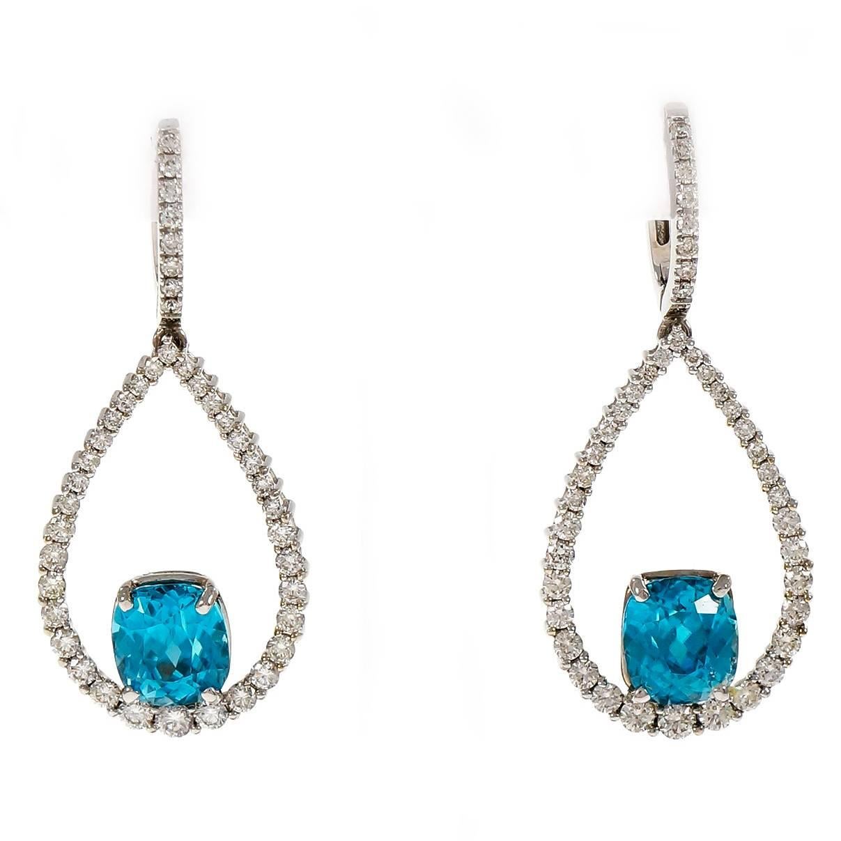 6.97 Carat Teal Blue Zircon Diamond Dangle 14k white Gold Earrings made in the Peter Suchy Workshop

2 cushion bright greenish blue Zircon, 6.97cts, VS
84 round full cut diamonds, approx. total weight 1.50cts, G – H, VS2
14k white gold
Tested and