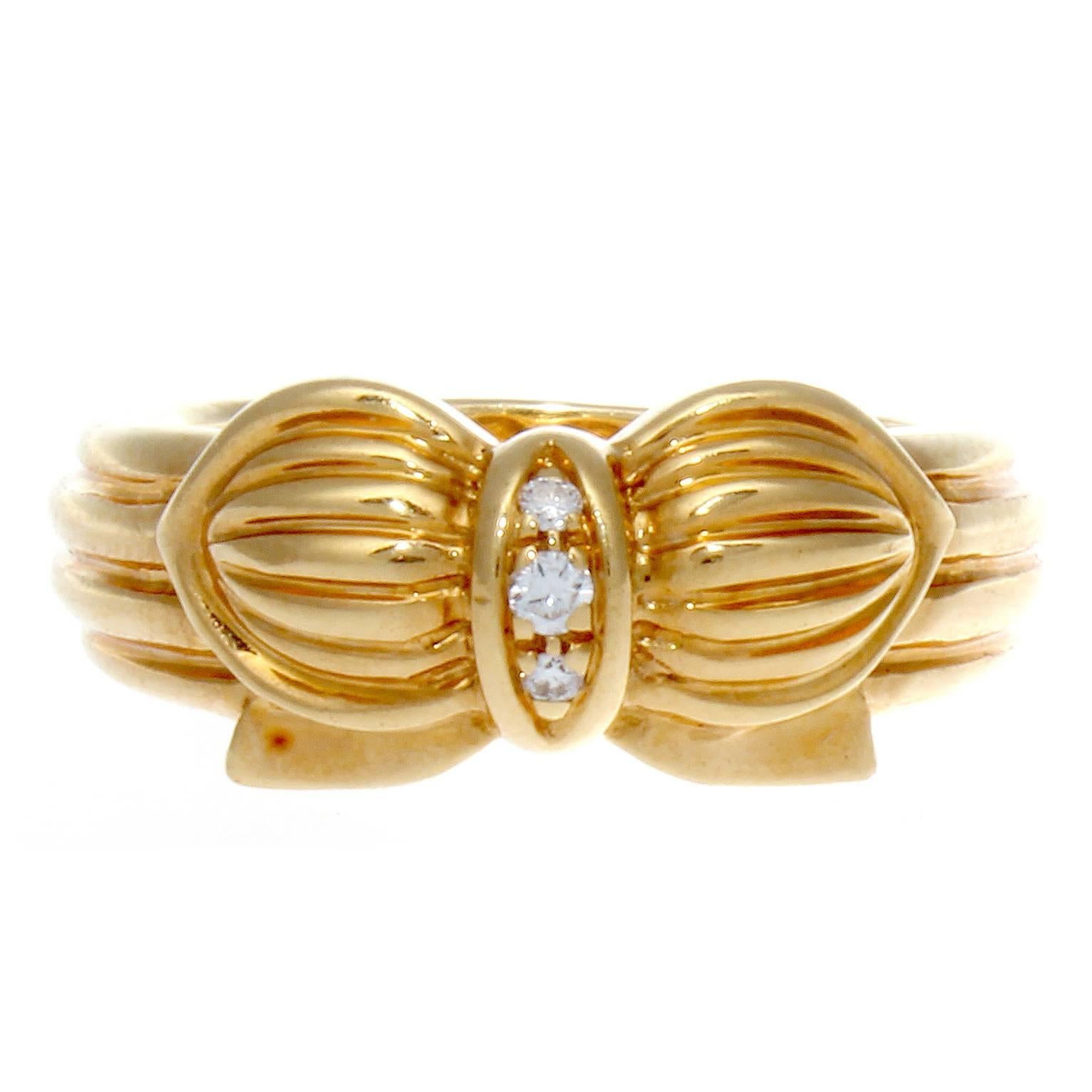 France has always been recognized for its style and fashion and the jewelry created there is no exception. The ring is designed with three near colorless diamonds and fashioned with rolling contours of 18k yellow gold creating this bow motif. Signed