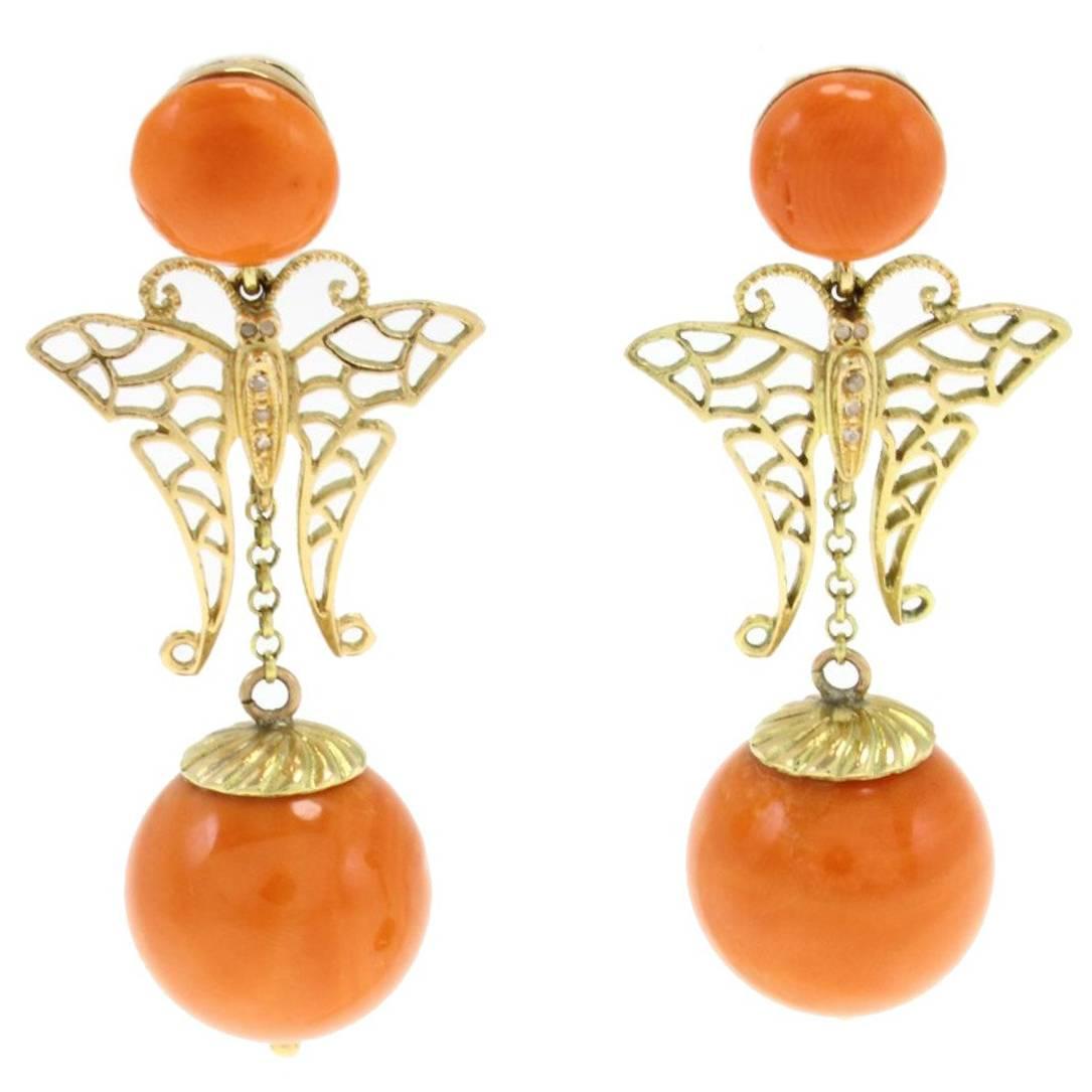 Pendants d'oreilles en or jaune avec sphères de corail orange, diamants en forme de papillon