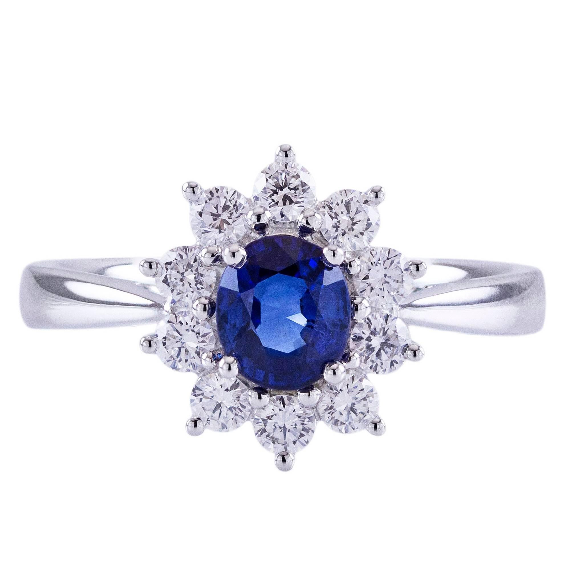 This ring features a natural blue sapphire center stone weighing 0.91 carats. The sapphire has a nice royal blue color and is eye clean. Surrounding the sapphire are 10 round brilliant diamonds weighing 0.50 carats total. Made in 18k white gold.