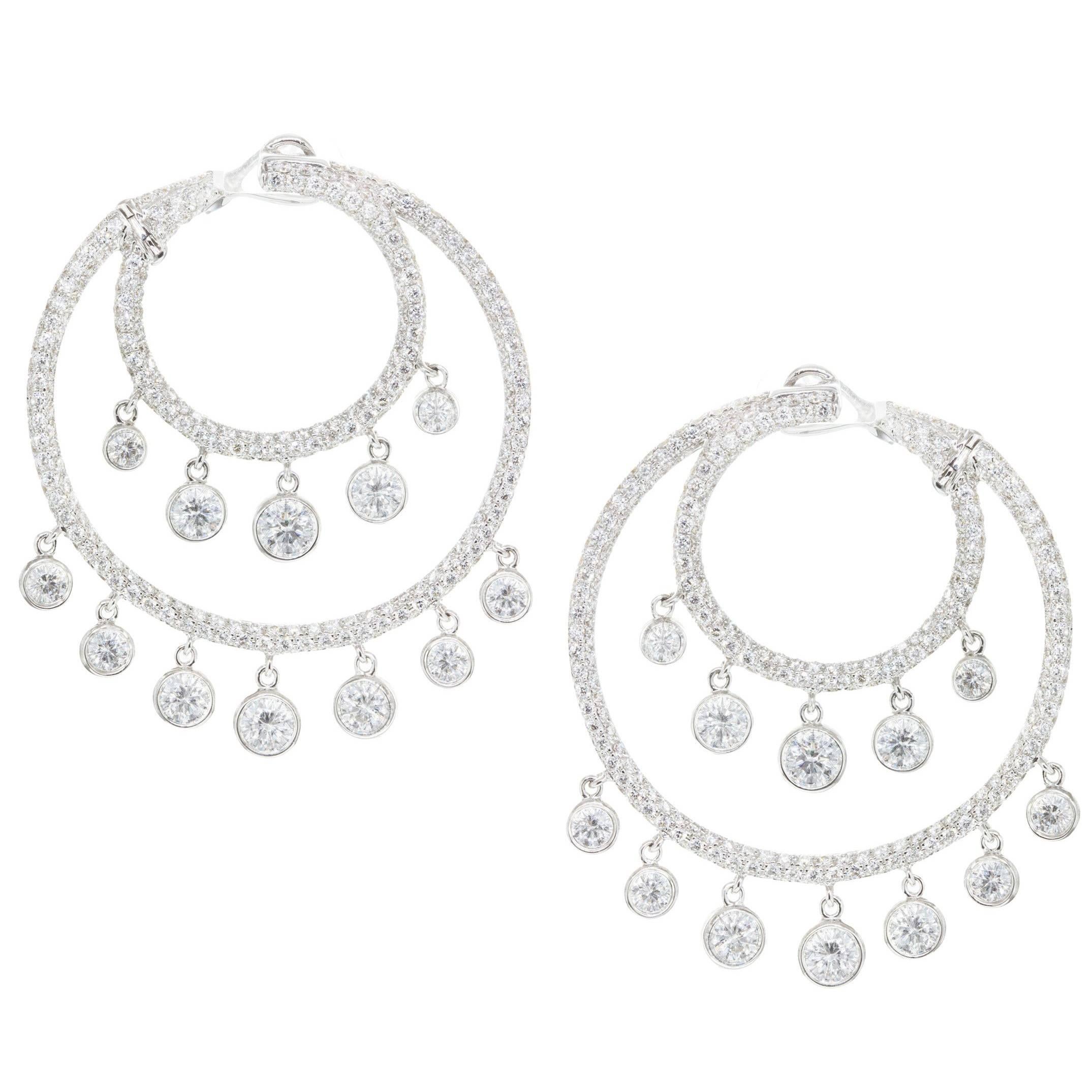 Each earring features two eccentric circles micro-pave set with round brilliant melee diamonds. Dangling from each circle are round brilliant diamonds that graduate larger as it gets to the center. Total weight of the diamonds is 5.32 carats. Made