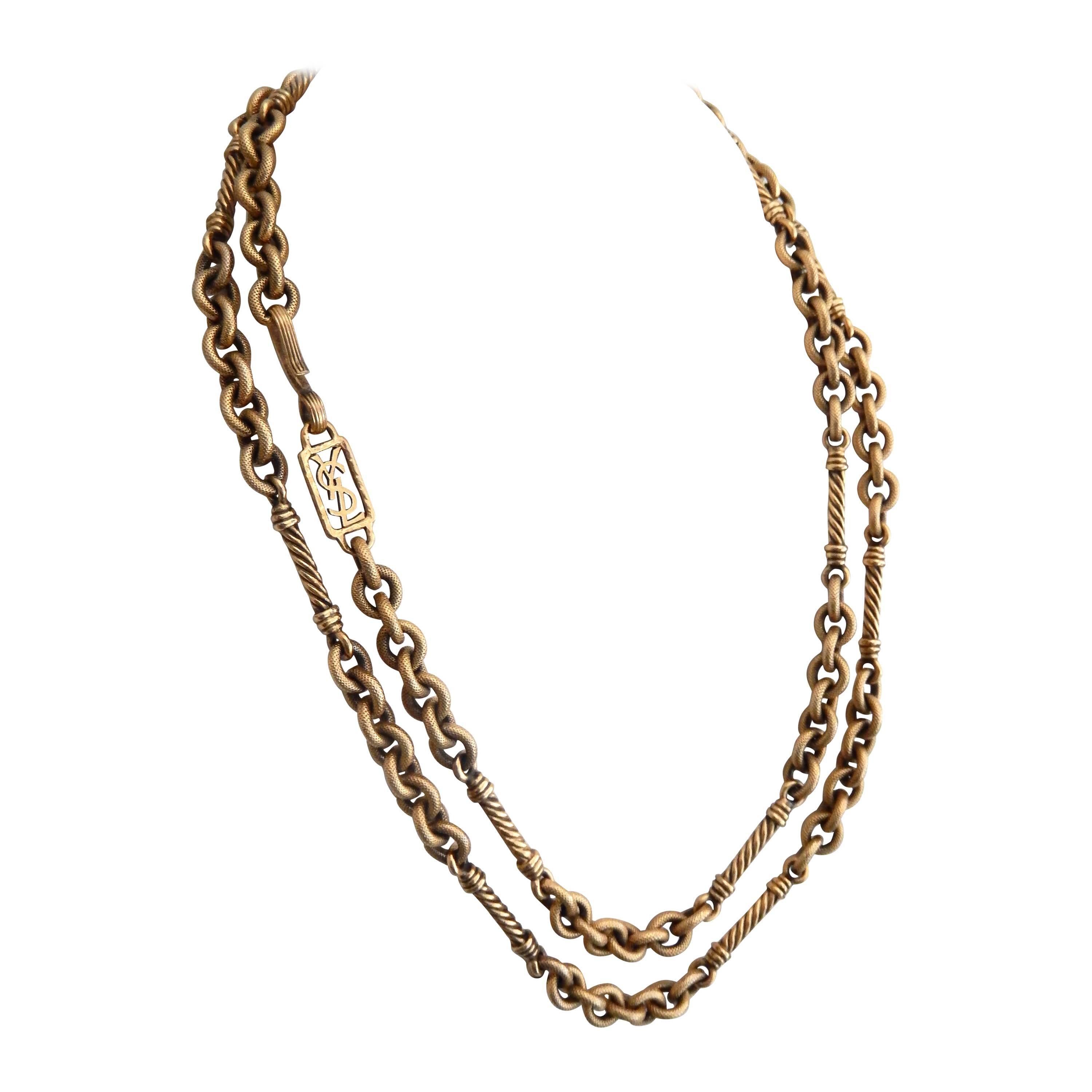 A sophisticated, modern sautoir by Yves Saint Laurent that combines spiral and round links of textured, gilt metal.   The hook clasp allows for the necklace to be doubled. Integrated signature tag.

An icon of French couture, Yves Saint Laurent