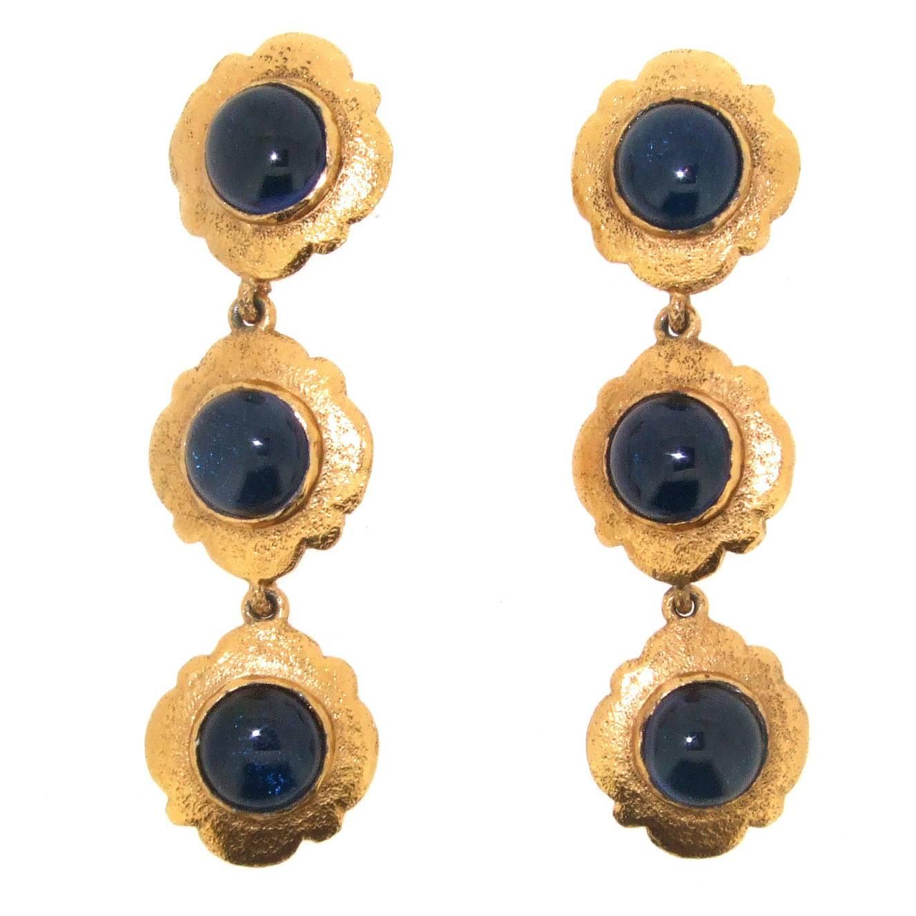 A pair of clip on chandelier earrings by Chanel with sapphire royal blue glass set in gold plated metal. 

The stamp dates the earrings to collection 25 by Victoire De Castellane who was the head designer between 1986 and 1989. 