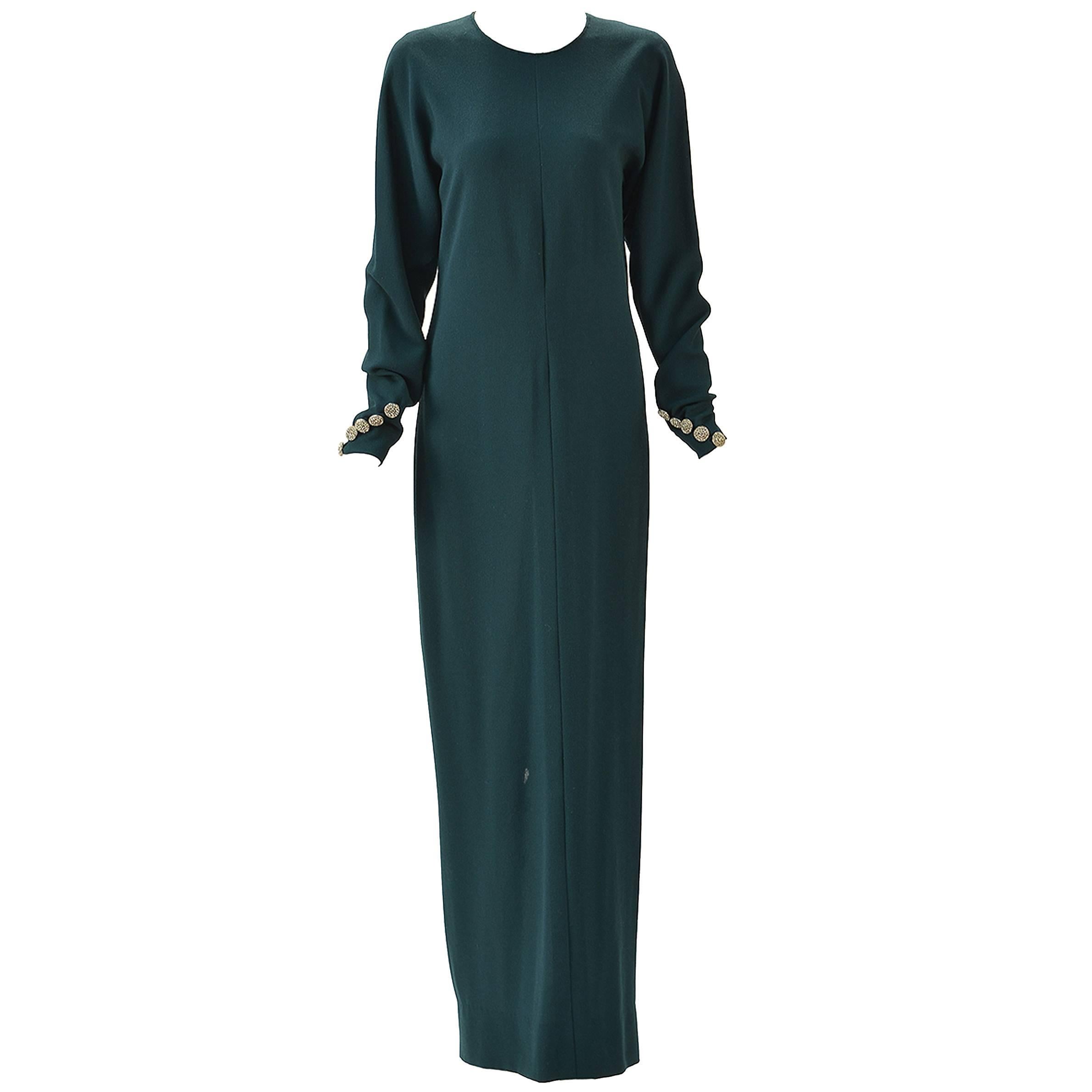 This gorgeous and glamorous Galanos long green dress is the elegance you need in your life. Scoop neck with long bat-wing sleeves are buttoned at cuffs with five silver rhinestone buttons. Open back tying at neck. Gathered at waist with back zipper.