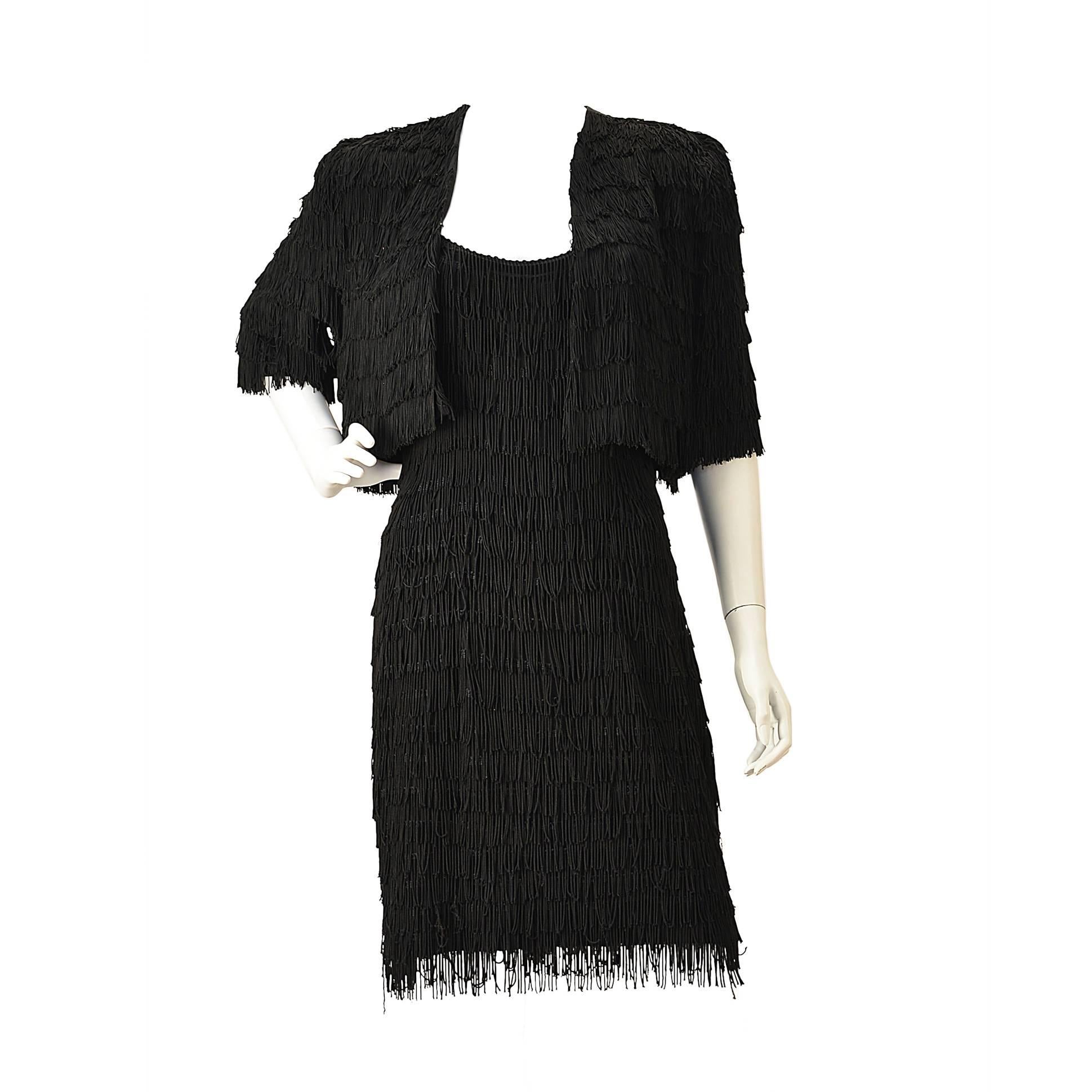 Sassy black fringe dress and bolero. The dress is composed of a knit wear fabric with horizontal layers of short black fringe. The dress and bolero have movement and can add drama to any party. All you need are some black heels and swagger. 
Bolero