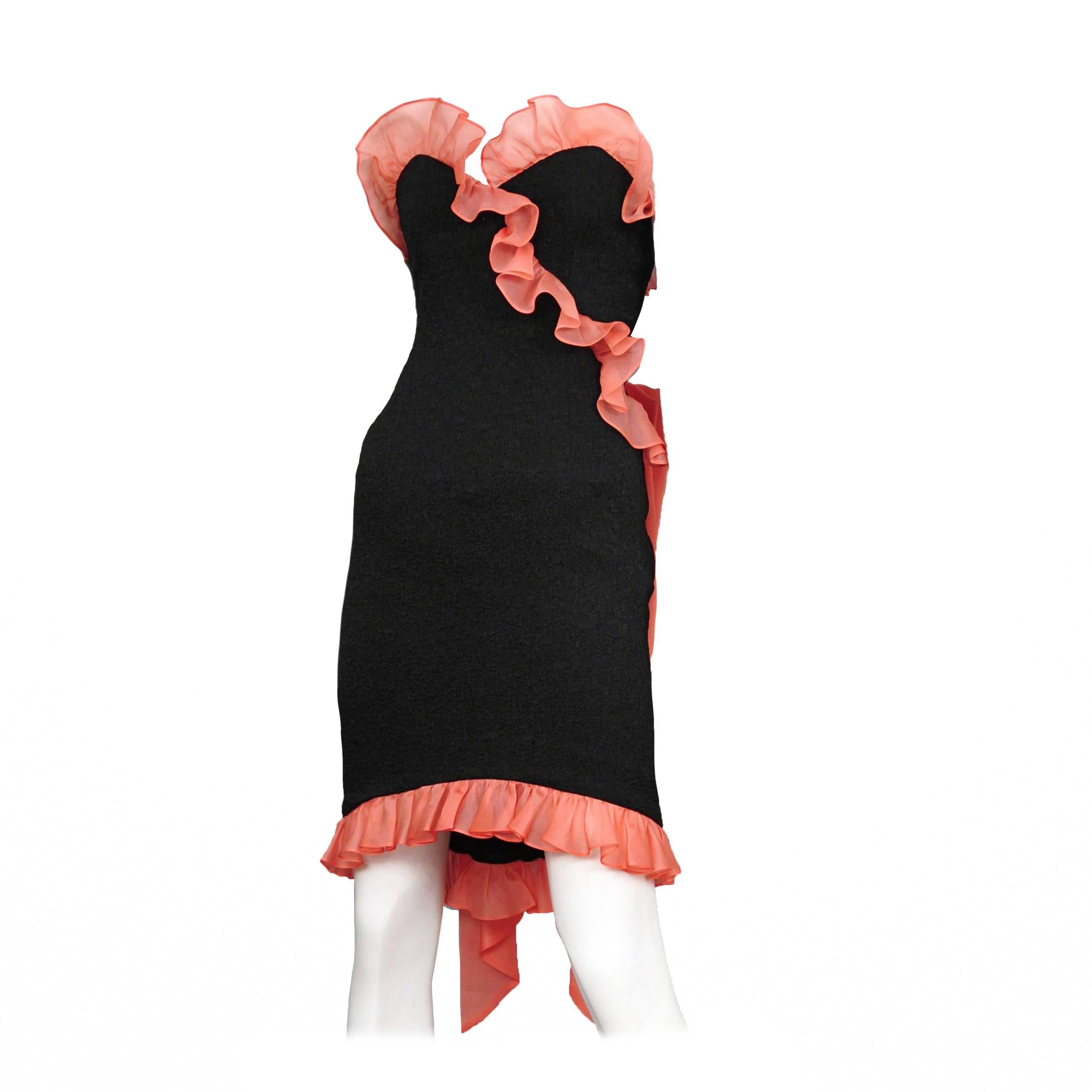 Vintage Yves Saint Laurent black cocktail dress featuring a silk coral ruffle along the sweet heart neckline and hem, and a giant bow at the back. Circa 1987.
