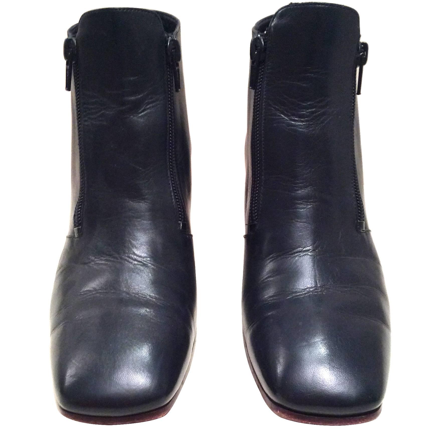 Presented here is a stunning pair of boots from the Celine fashion house. These gently worn navy leather boots are a size 37.5 in their original box. They have a beautiful red plastic type material of a two inch rectangular heel. The boots have two