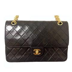 Vintage Chanel black 2.55 classic double flap bag with golden CC motif closure.