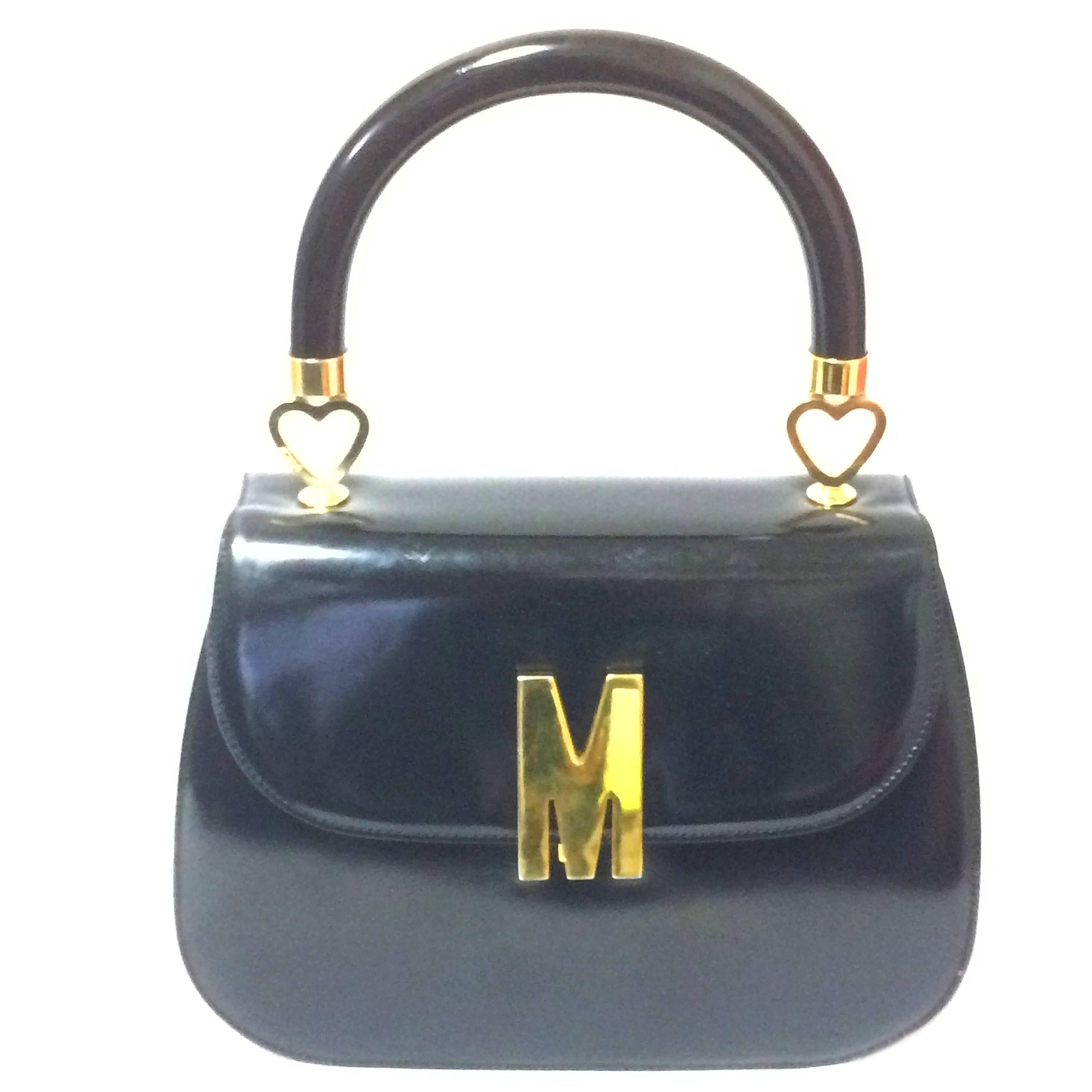 Vintage MOSCHINO black patent enamel Kelly style handbag with M logo and heart For Sale