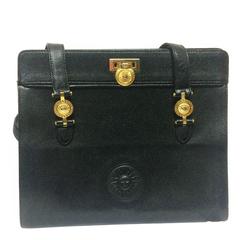 Vintage Gianni Versace black leather tote bag with golden sunburst motifs.