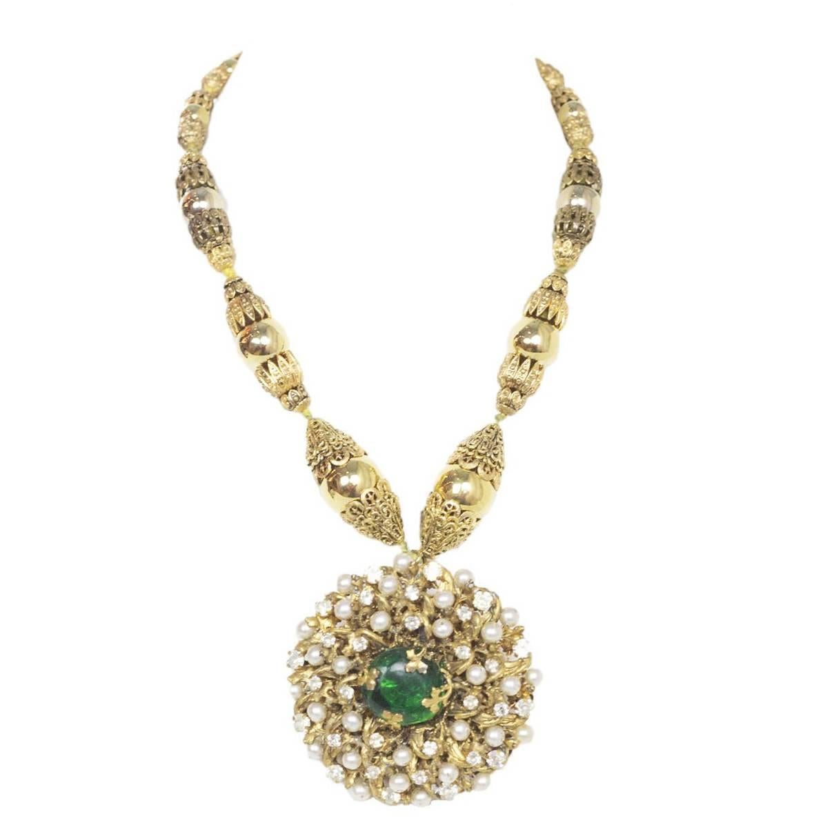 Chanel 3 Star Couture Faux Pearl And Stone Necklace. Features couture filigree beaded strand with over-sized pearl and crystal encrusted pendant with green gripoix center.

Year of Production: Circa 1950's
Color: Gold, green, ivory
Materials: Metal,