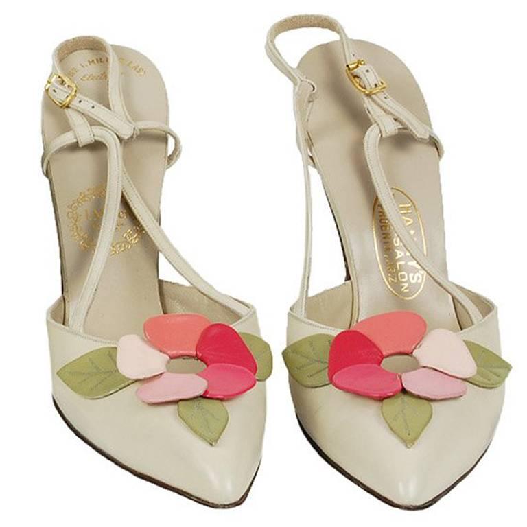 As if to prove mid-century gals were unafraid of color, these sculpted stilettos mitigate their neutral bone ground with a fully-articulated leather peony in shades of pink and green on each vamp. Moreover, they hail from legendary Phoenix
