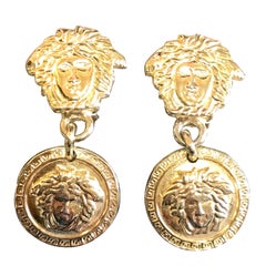 Vintage Gianni Versace gold tone medusa head, face motif dangle earrings.