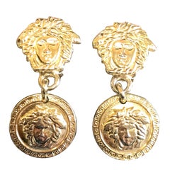 Retro Gianni Versace gold tone medusa head, face motif dangle earrings. 