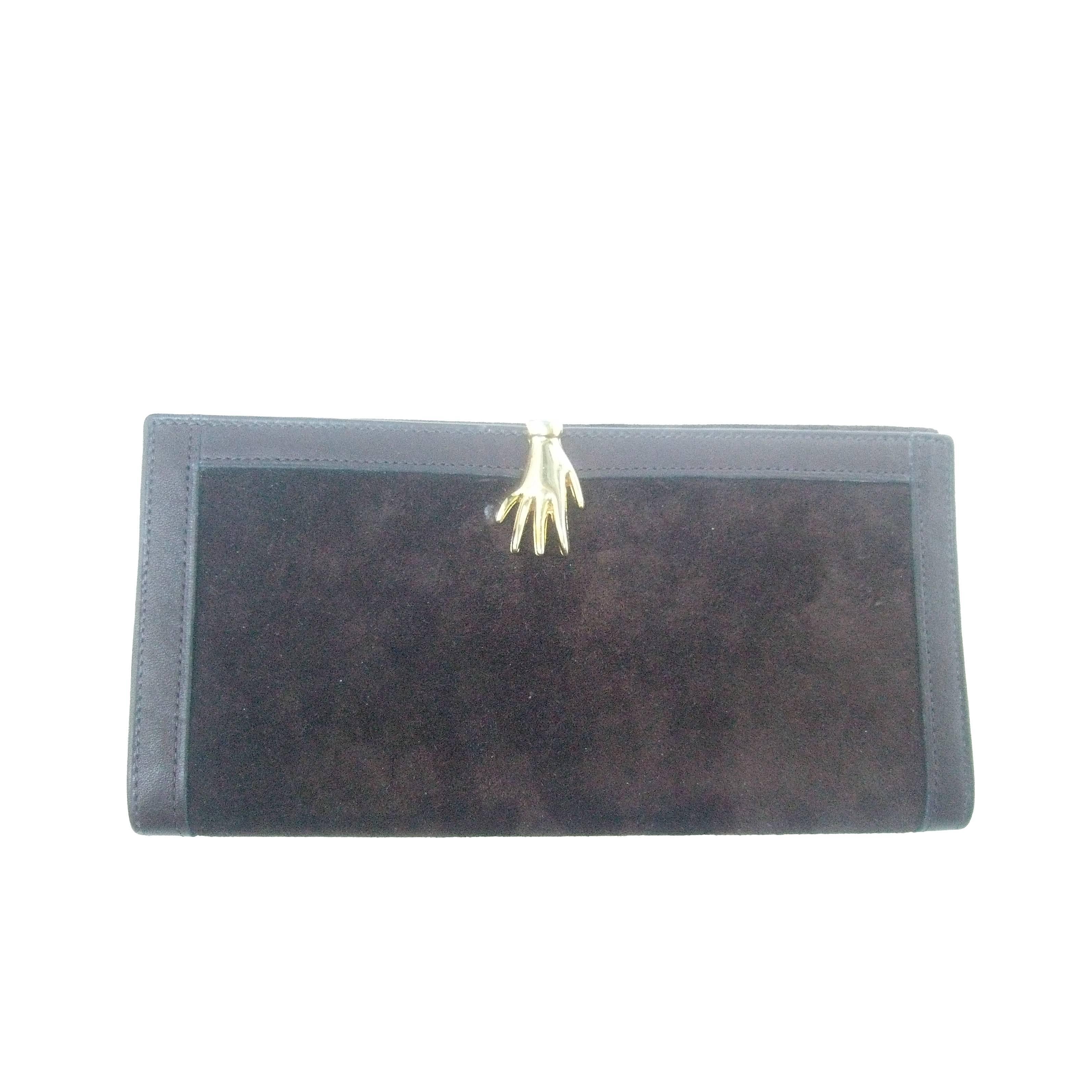 Gucci Italy Rare chocolate brown suede hand clasp wallet 
The stylish Italian wallet is covered with plush brown 
suede on both exterior sides

The unique wallet is adorned with a gilt metal hand
clasp mechanism. The edges of the wallet are