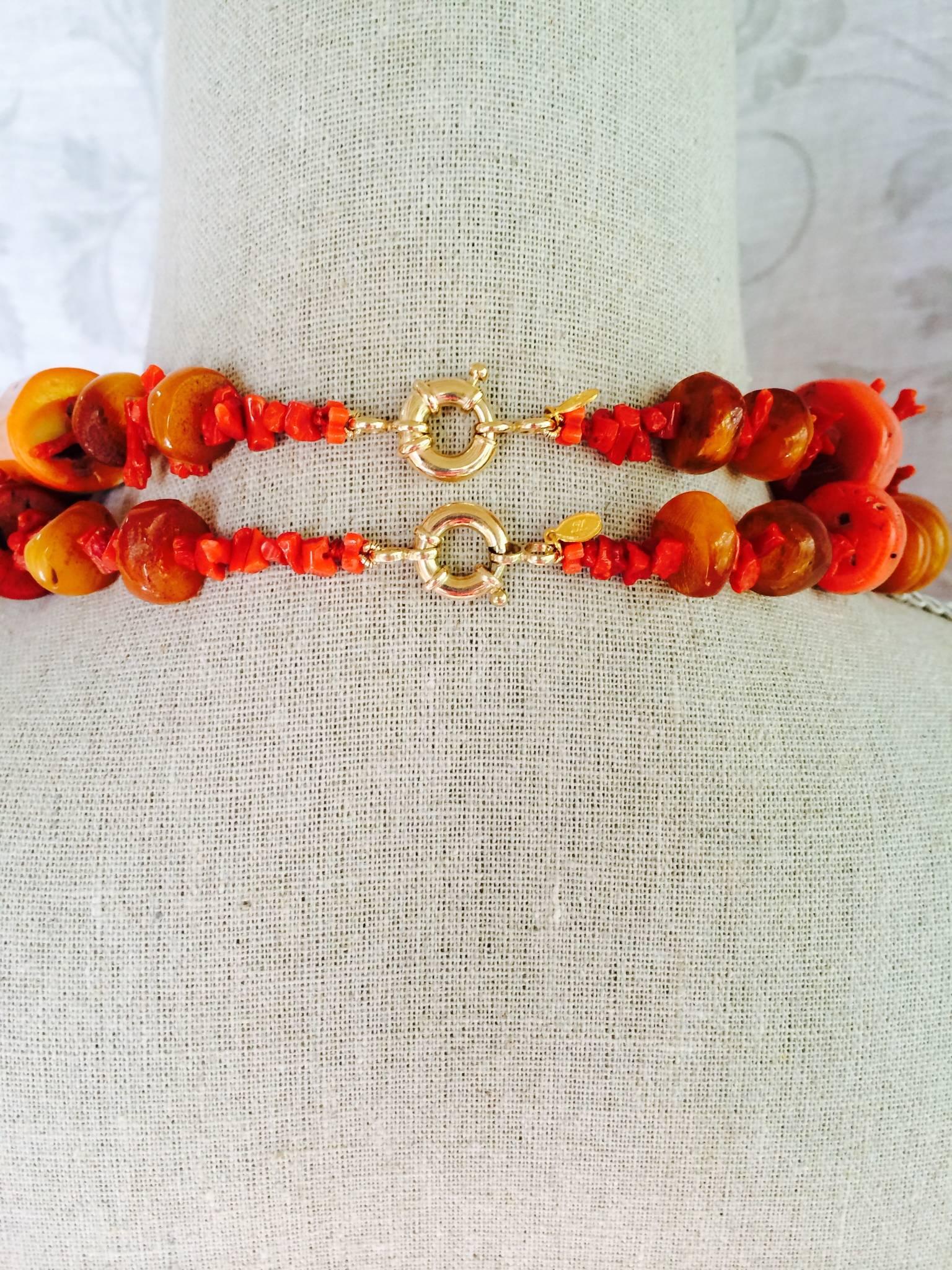 A pair of Marina J original graduated coral and amber necklaces. 27 and 31 inches long, these marvelous necklaces have 14k yellow gold clasps. Nested one under the other, these coral and amber necklaces are particularly attractive. The large old