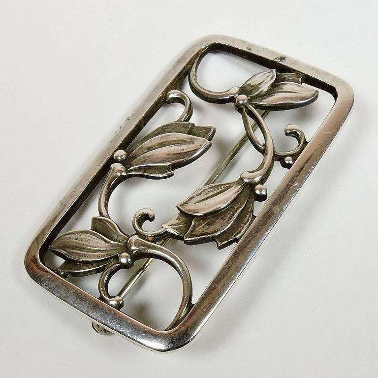 Georg Jensen Art Nouveau floral sterling silver brooch, Denmark, 20th century, marked “Georg Jensen, 925S, Denmark, 295.” Set within a rectangular silver frame, in a Minimalist, openwork design with stylized flowers. Designed by Georg Jensen, just