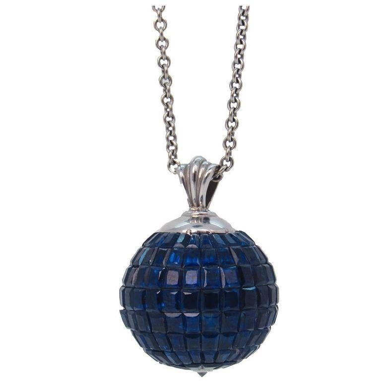 Sapphire, diamond and 14-karat white gold globe form pendant necklace. Elegant globe form pendant encrusted with baguette cut sapphires, ending in a diamond point, suspended from a later 14-karat white gold chain with lobster clasp, marked 585.