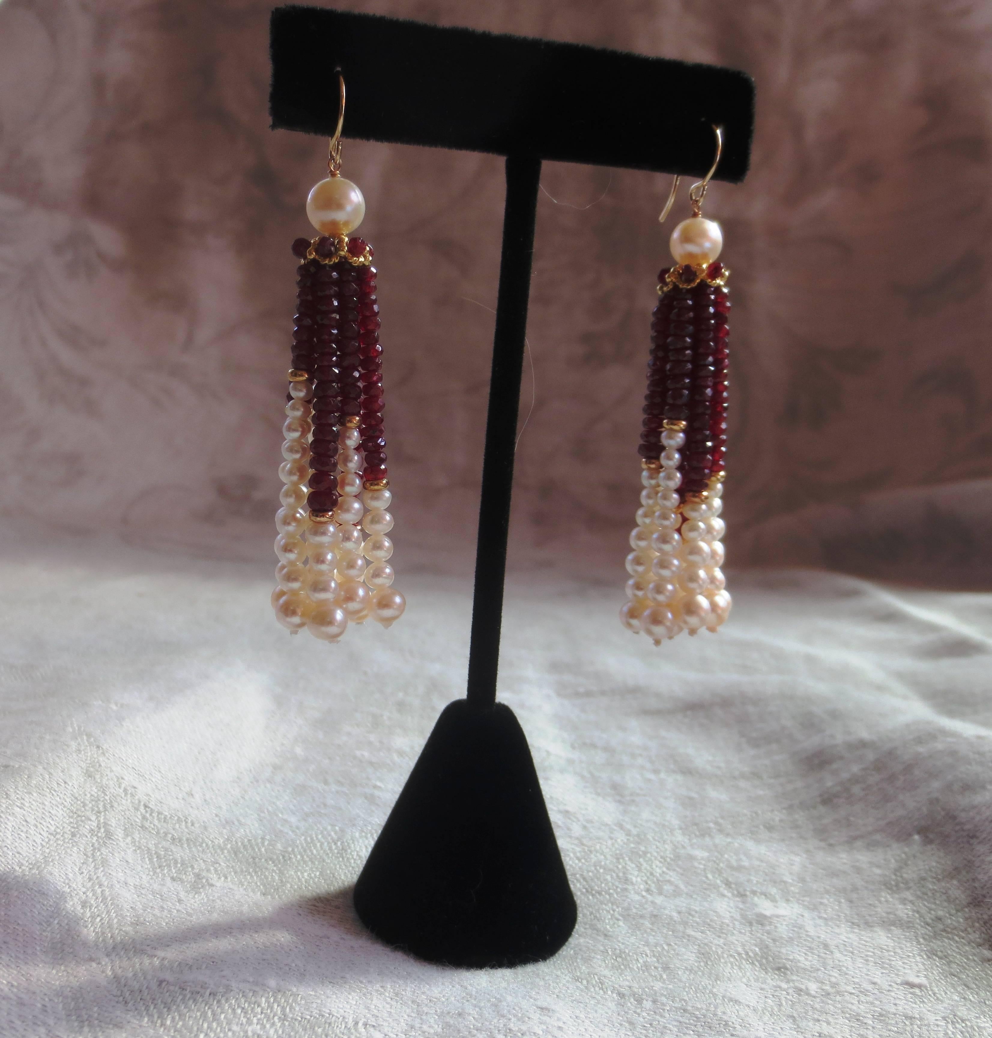 These stylish earrings feature a large 6 mm cultured pearl atop a unique gold piece. Through this gold piece are laced tassels made of ruby beads and graduated sizes of cultured pearls, separated by 3 mm 14 karat gold rondells, and the ear wire is