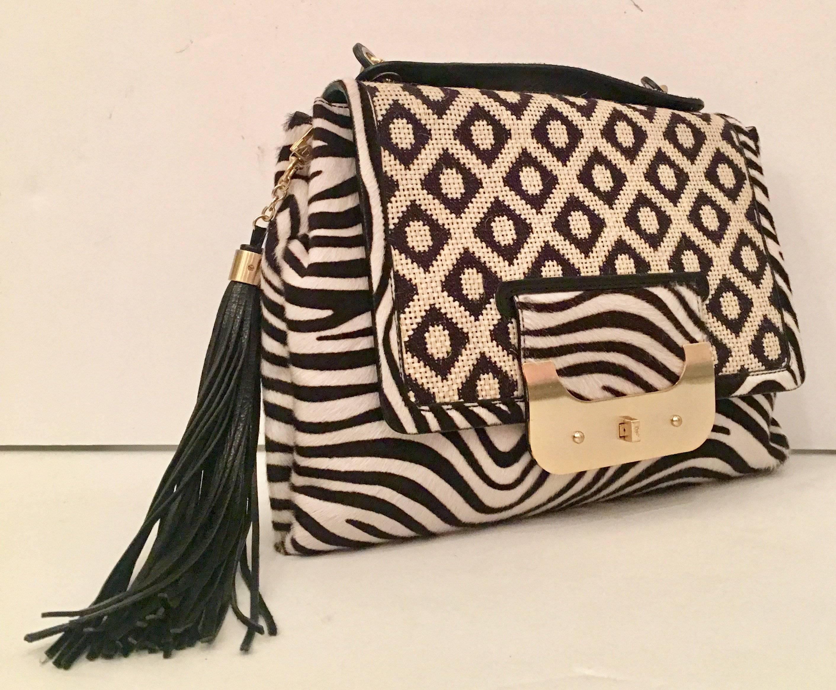 2012 collection limited edition "Harper" large cross boy black and white hand bag. This stylish hand bag features, authentic hide hair in a zebra print with geometric print cruel front flap detail and a leather tassel ornament. Hardware is