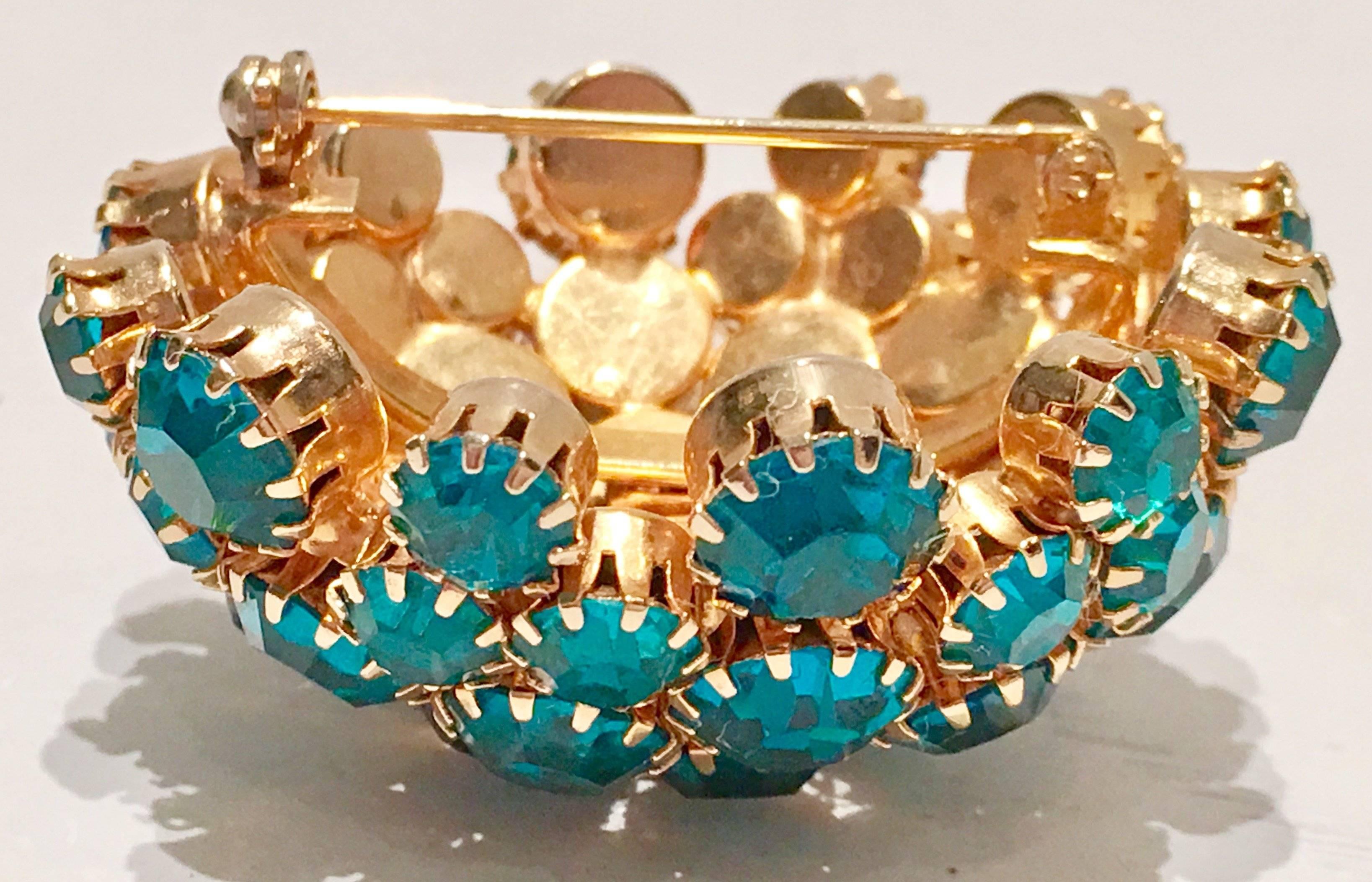 Warner vintage teal Swarovski crystal prong set big dome gold tone brooch or pin. Signed on the underside, Warner. Crystal rhinestones vary in size from. 50" inches and smaller.