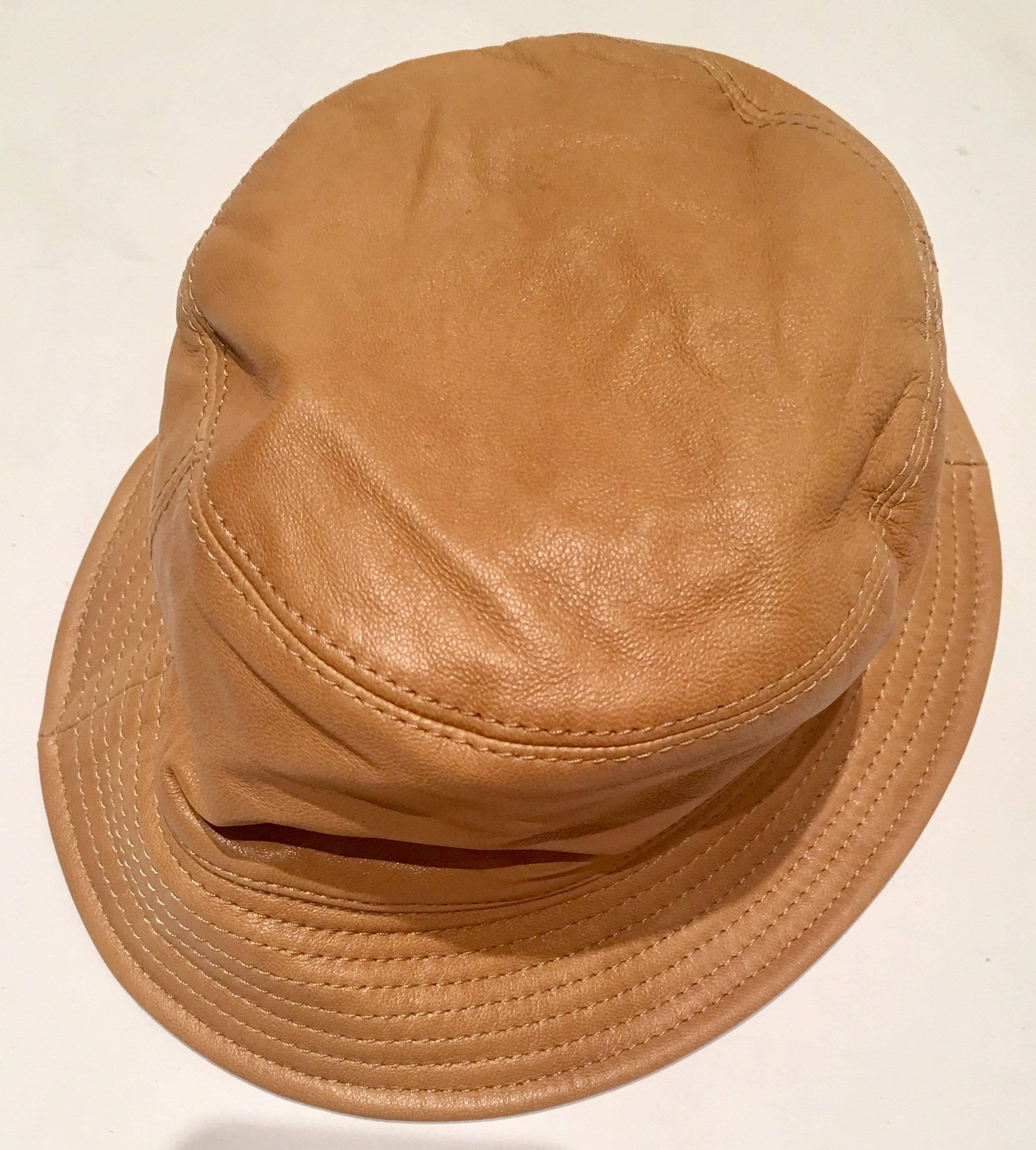 Iconic Burberry check and camel leather bucket hat. Original manufacturer tag intact, sewn into interior and reads, Burberry London. Interior diameter, 6.25