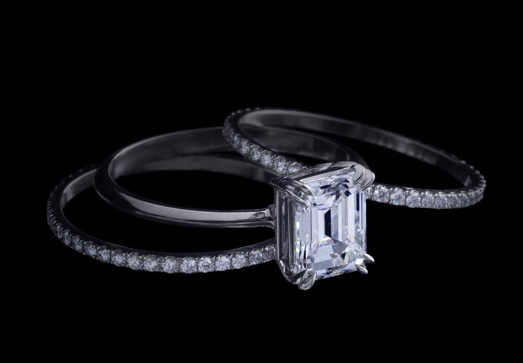 An Alexandra Mor three ring set , with a 1.59 Ct Emerald Cut  Center , F , VS1, with a GiA Gradiing report, diamond set on a platinum knife-edged band. The two adjacent platinum bands are set with 1 mm floating diamond melee. Limited edition of 50.