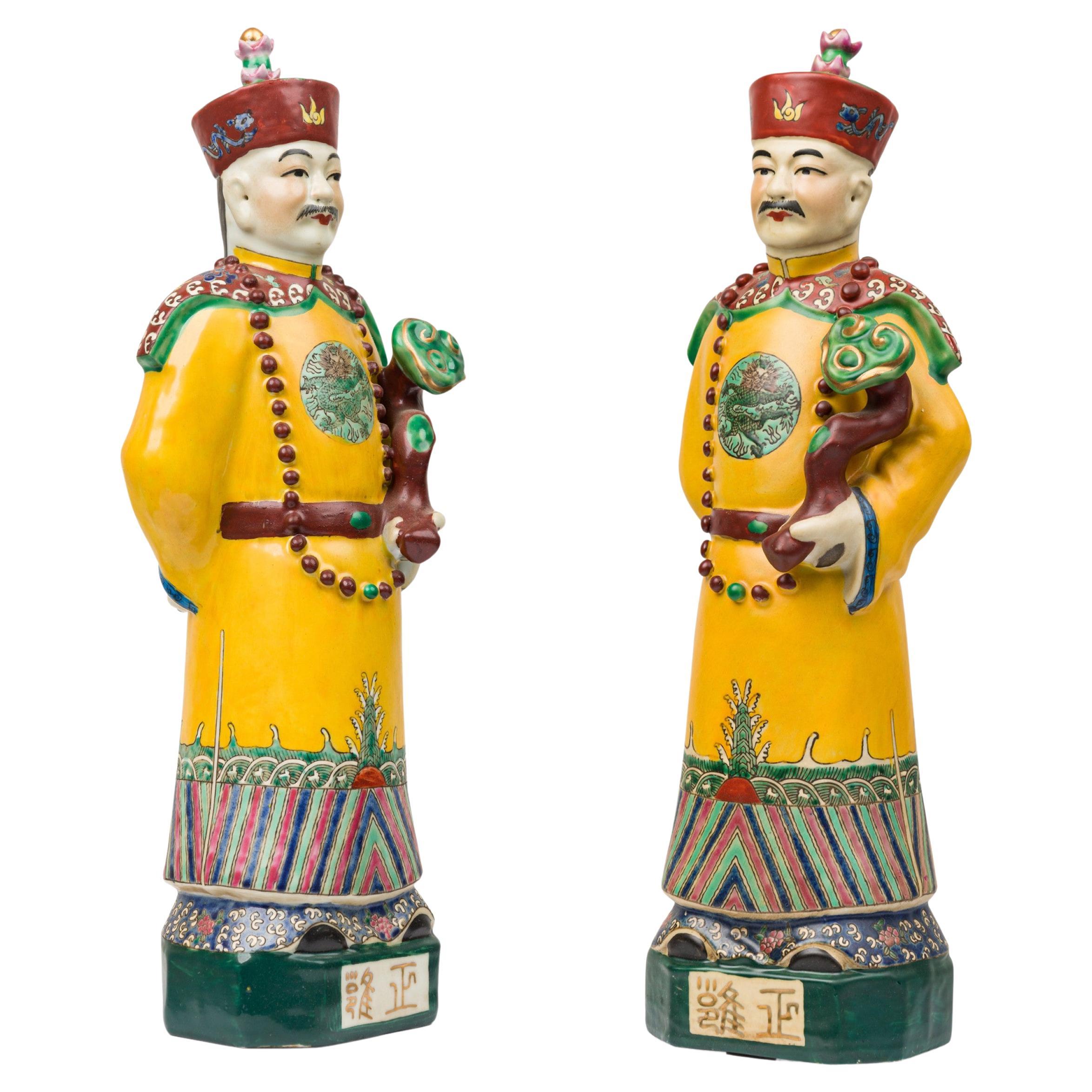 Paire de figures en céramique peintes chinoises représentant un empereur vêtu de jaune en vente