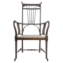 Antique Henry W Batley attr. An Aesthetic Movement walnut armchair with sinuous touches.
