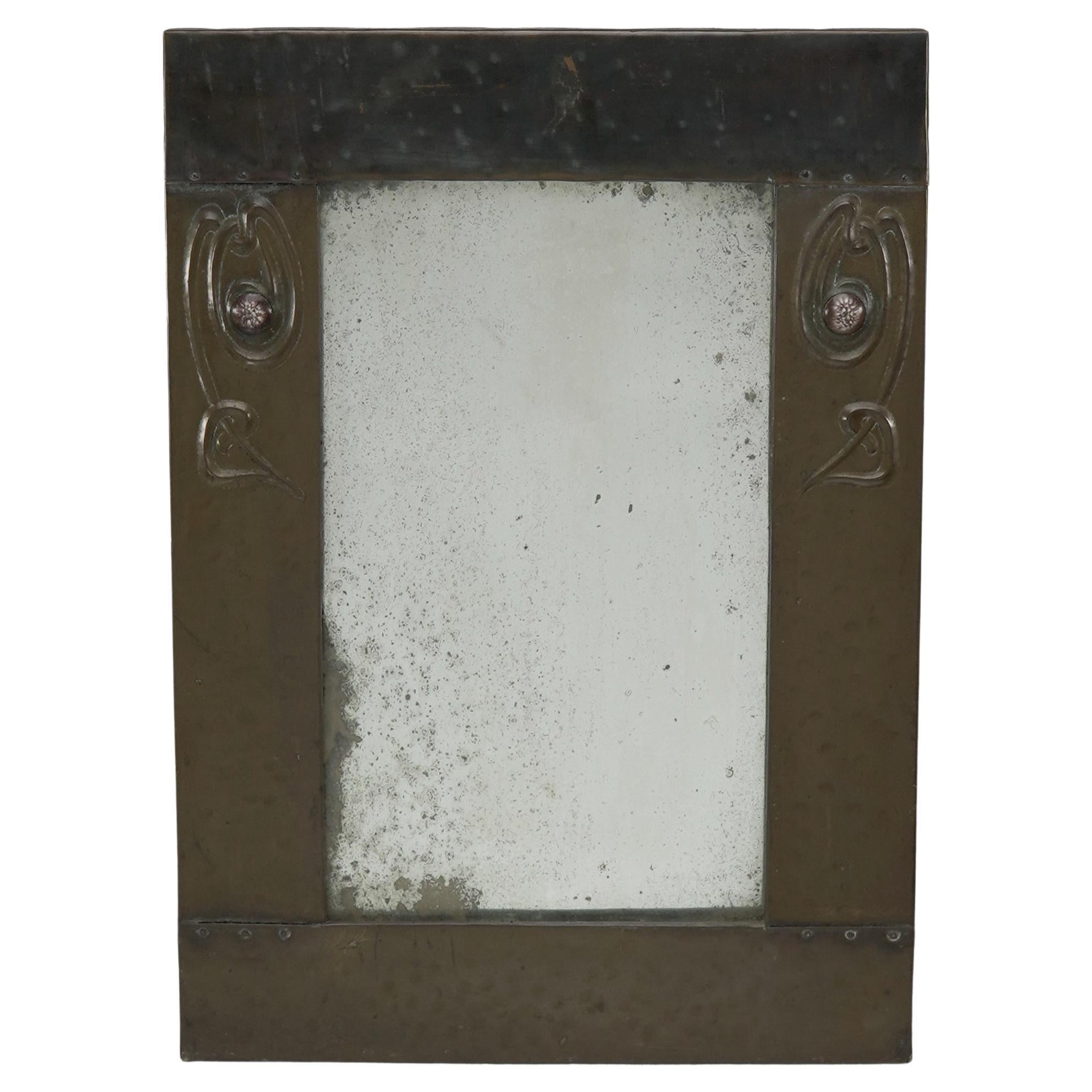 Liberty and Co. An Arts and Crafts copper mirror with floral details