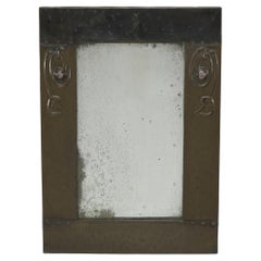 Liberty and Co. An Arts and Crafts copper mirror with floral details