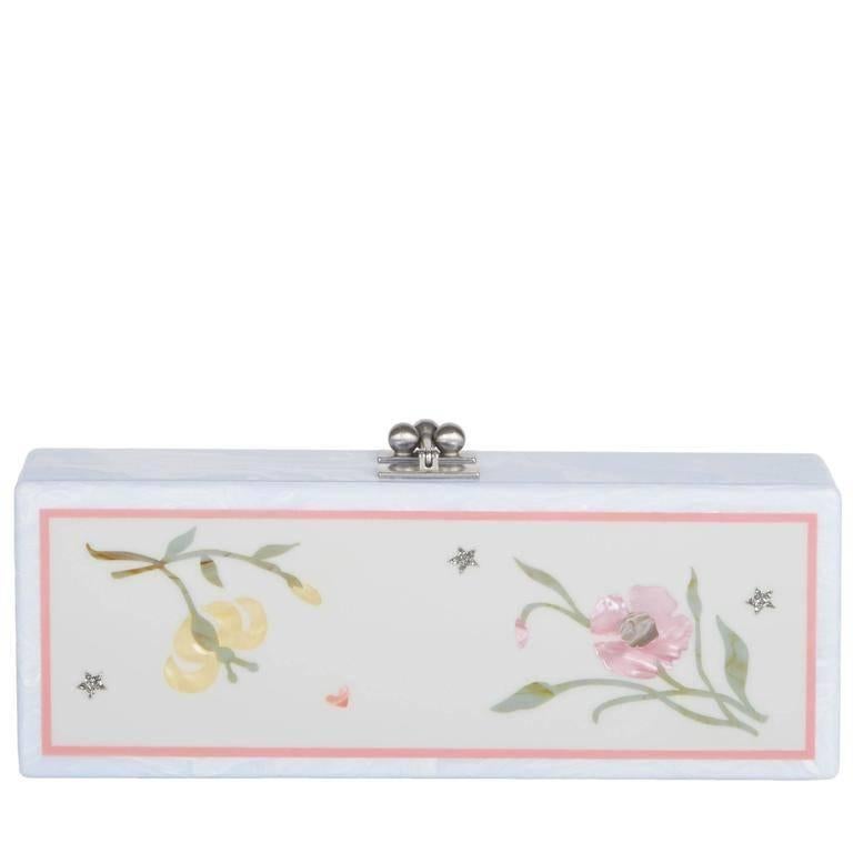 Flavia Jardin in mist blue featuring accents in dusty rose, moss, golden silk, guava and mocha, with silver hardware.

100% hand poured acrylic
Hinge closure with kiss-lock
Features an interior mirror with etched logo
Fits a smartphone including an