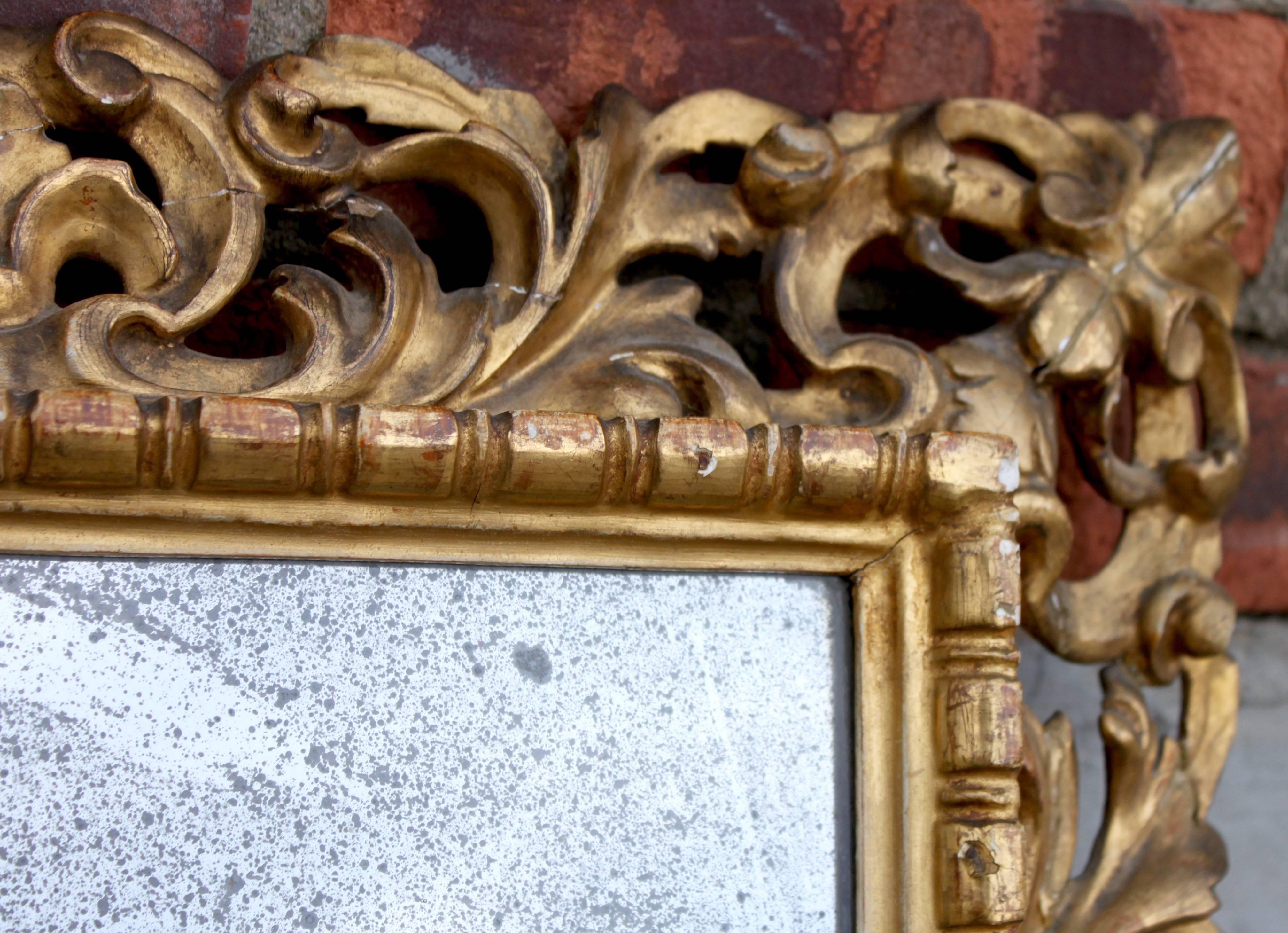 Intricate gilt woodcarving in excellent condition, mirror in original condition with vintage foil distress.