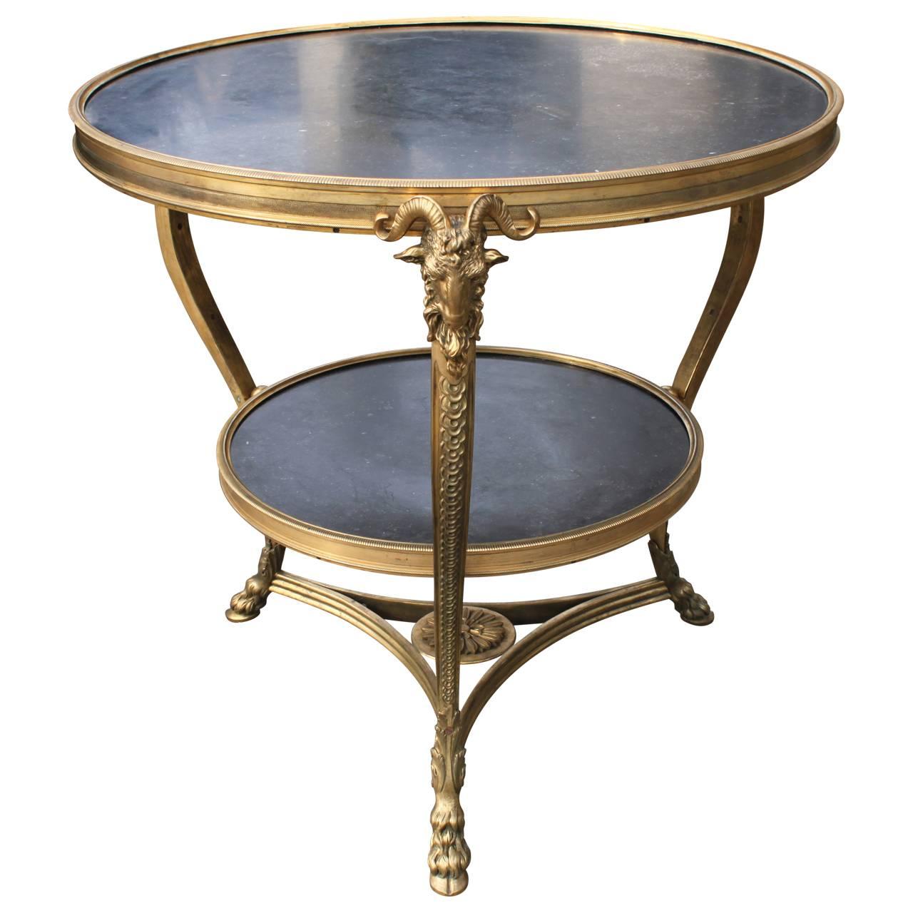 Two-tier gueridon table with ram head mounts and hoof feet, in a finely chased manner. Heavy and solid feel to table. Black marble have amazing indentations from fossils etc.
