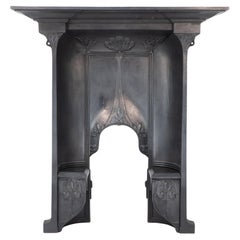 Antique Arts & Crafts cast iron fireplace with curved sides & stylized floral decoration