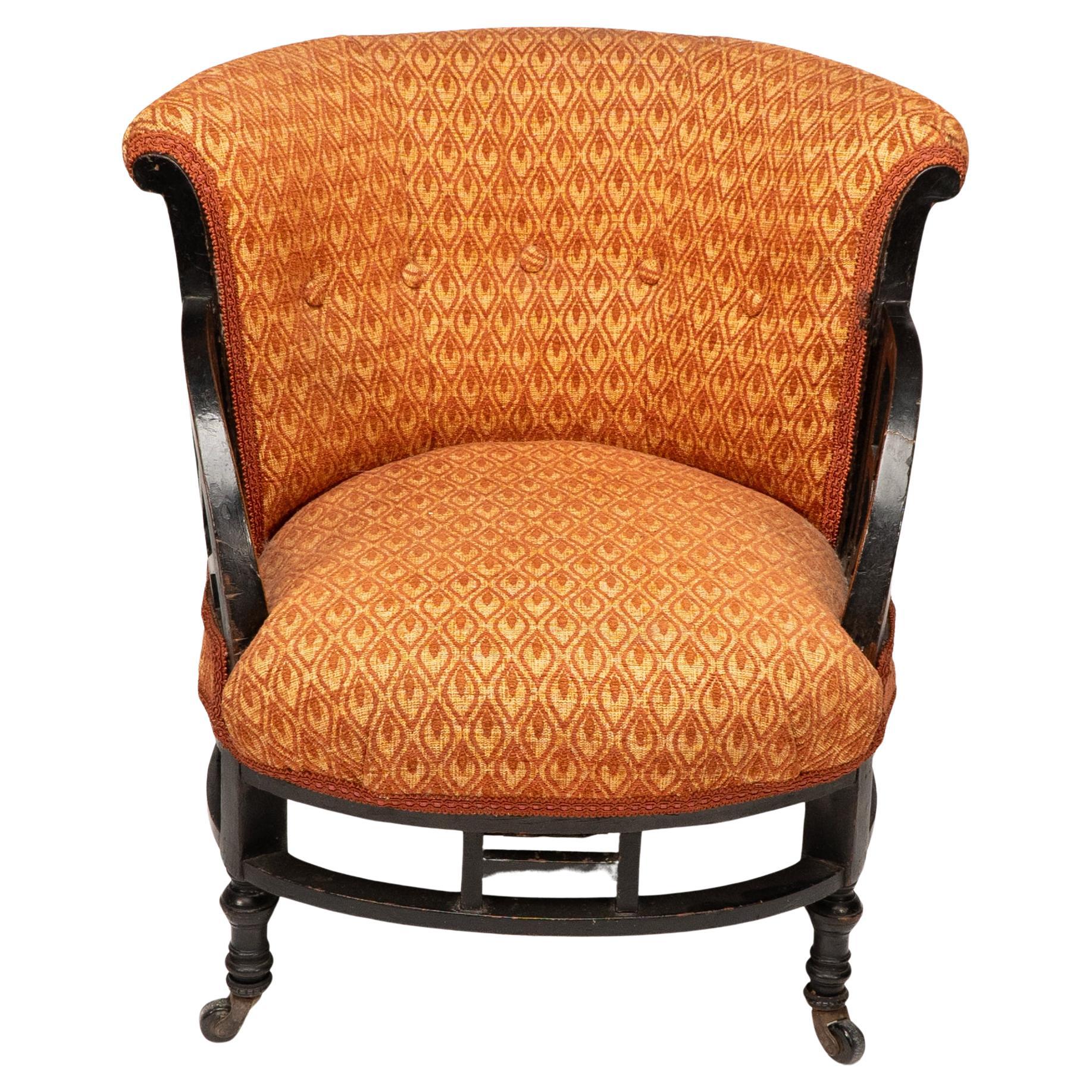 E W Godwin, atribuida, probablemente fabricada por Collinson & Lock.Silla de salón circular anglojaponesa de nogal con brazos en forma de abanico sobre patas bulbosas torneadas unidas por una camilla circular.Altura del asiento: 38 cmAltura del