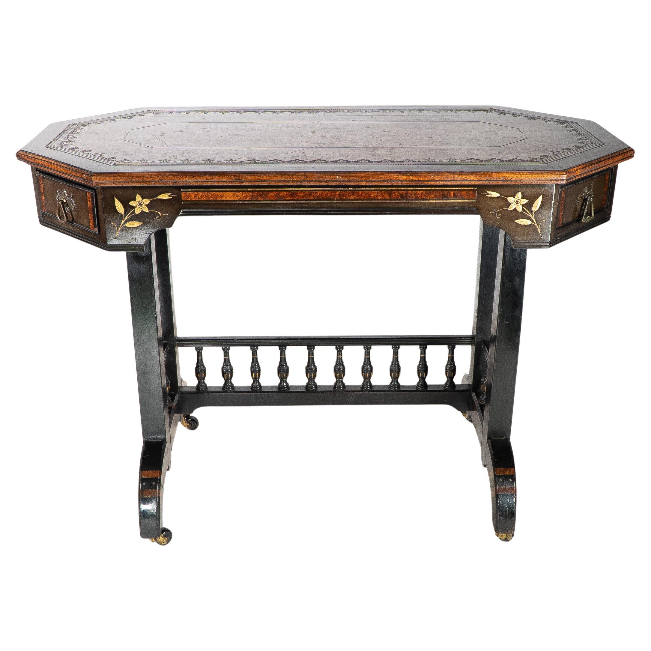 An Aesthetic Movement ebonized and parcel gilt writing desk with cantered corners and incized floral decoration and a tower turned gallery. Stamped David Waddington Ulphosterer Bolton on both drawers.
