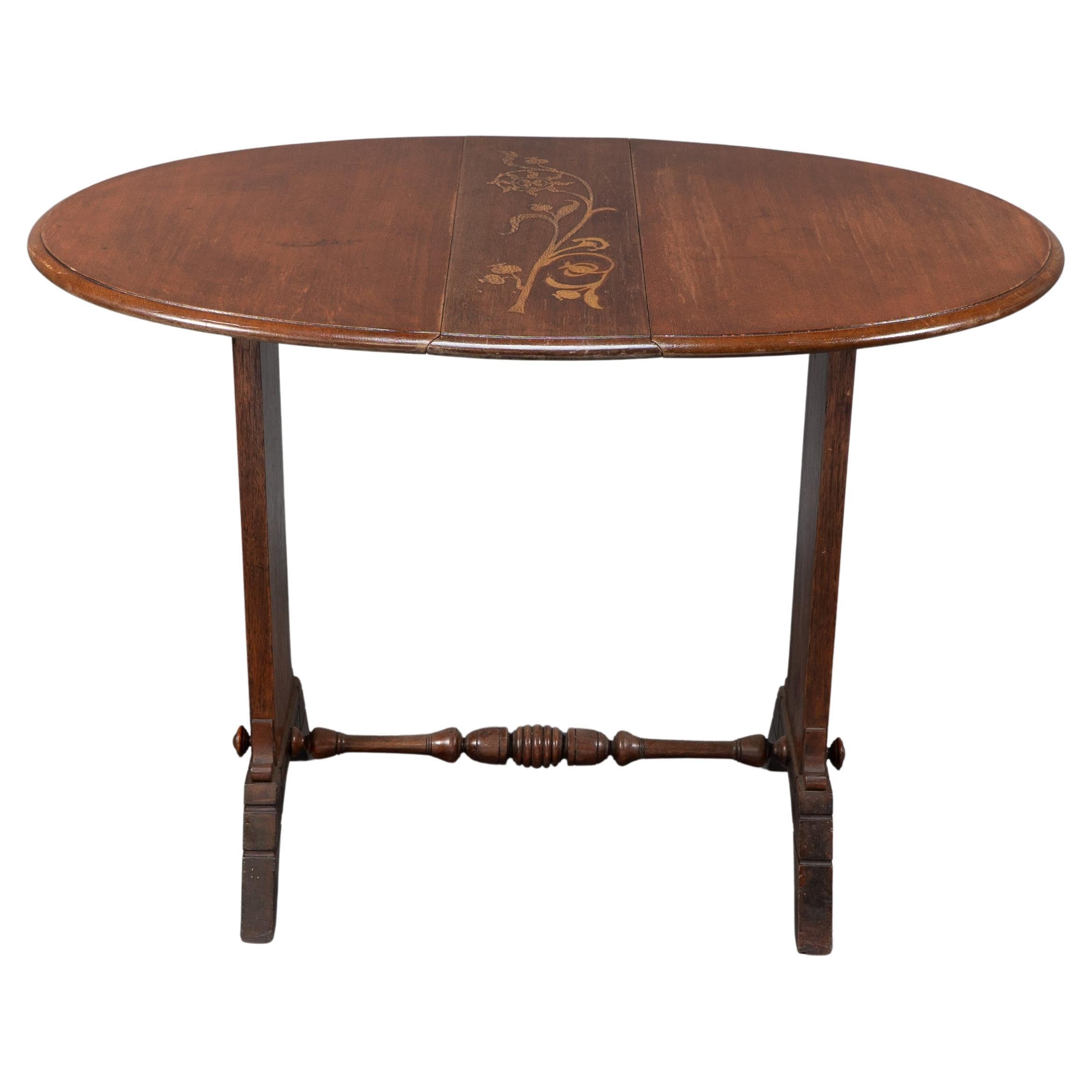 Thomas Jeckyll attributed. A subtle Anglo-Japanese style drop leaf oak occasional table, the oval top inlaid with a single flowing flower to the central panel, and a single flower rising from a planter in the Japanese style to both sides. The angled