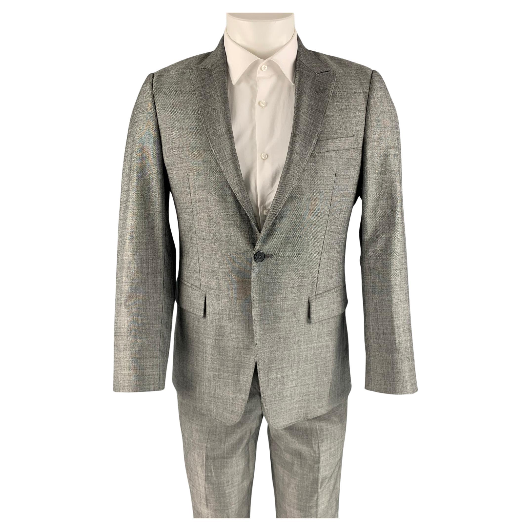 EMPORIO ARMANI suit comes in a grey wool and silk woven material with a full liner and includes a single breasted, single button sport coat with a peak lapel and a matching flat front trousers. Made in Italy.
Excellent Pre-Owned Condition. 
