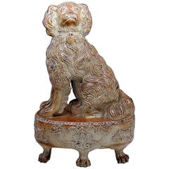 Antique saltglaze stoneware pottery figure of a spaniel seated on an oval base c