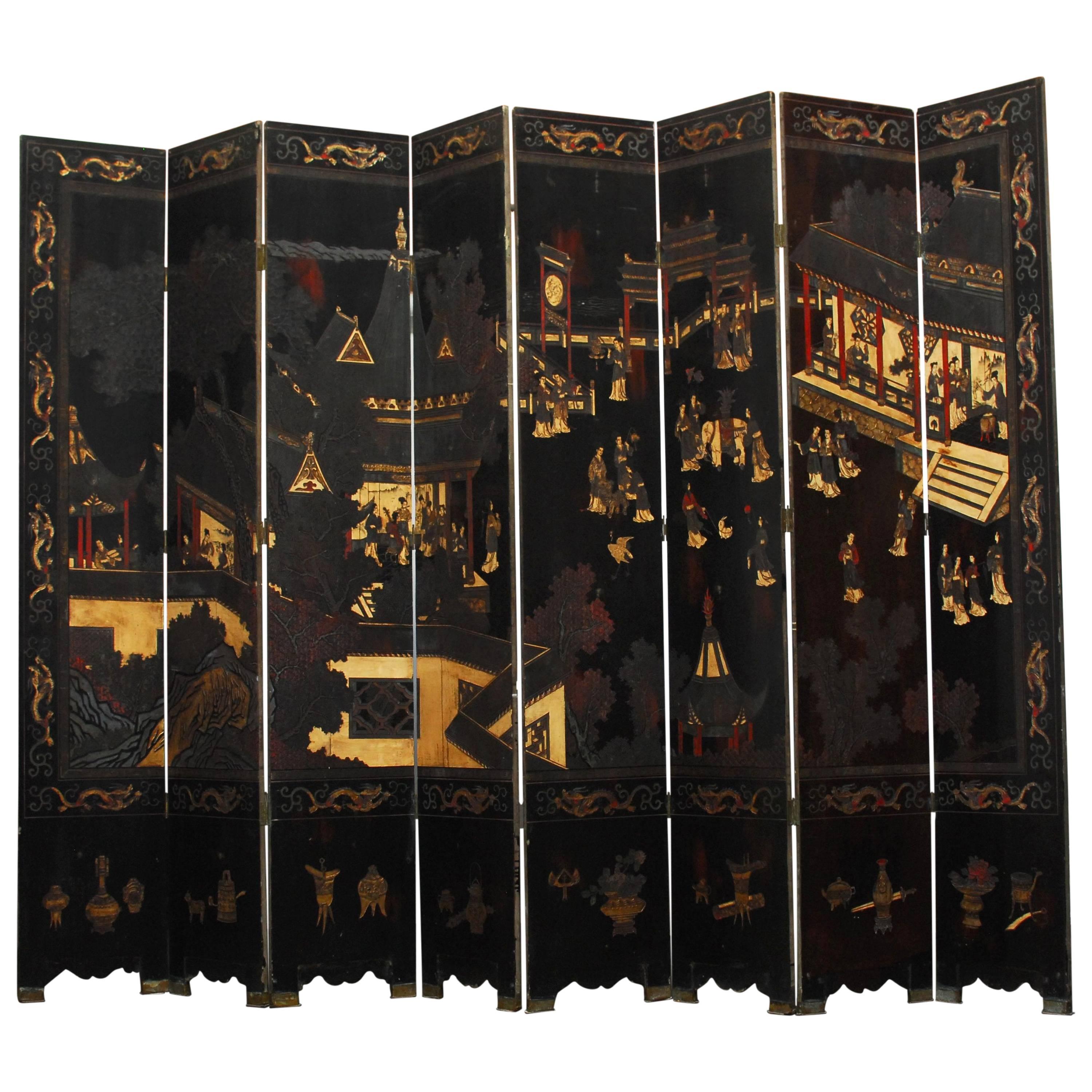 Huge eight-panel Coromandel screen featuring social gatherings of musicians, elephants and people around pagodas. Made of heavy, solid rosewood and carved from thick layers of lacquer. Double-sided with the front having a dragon border and scholars